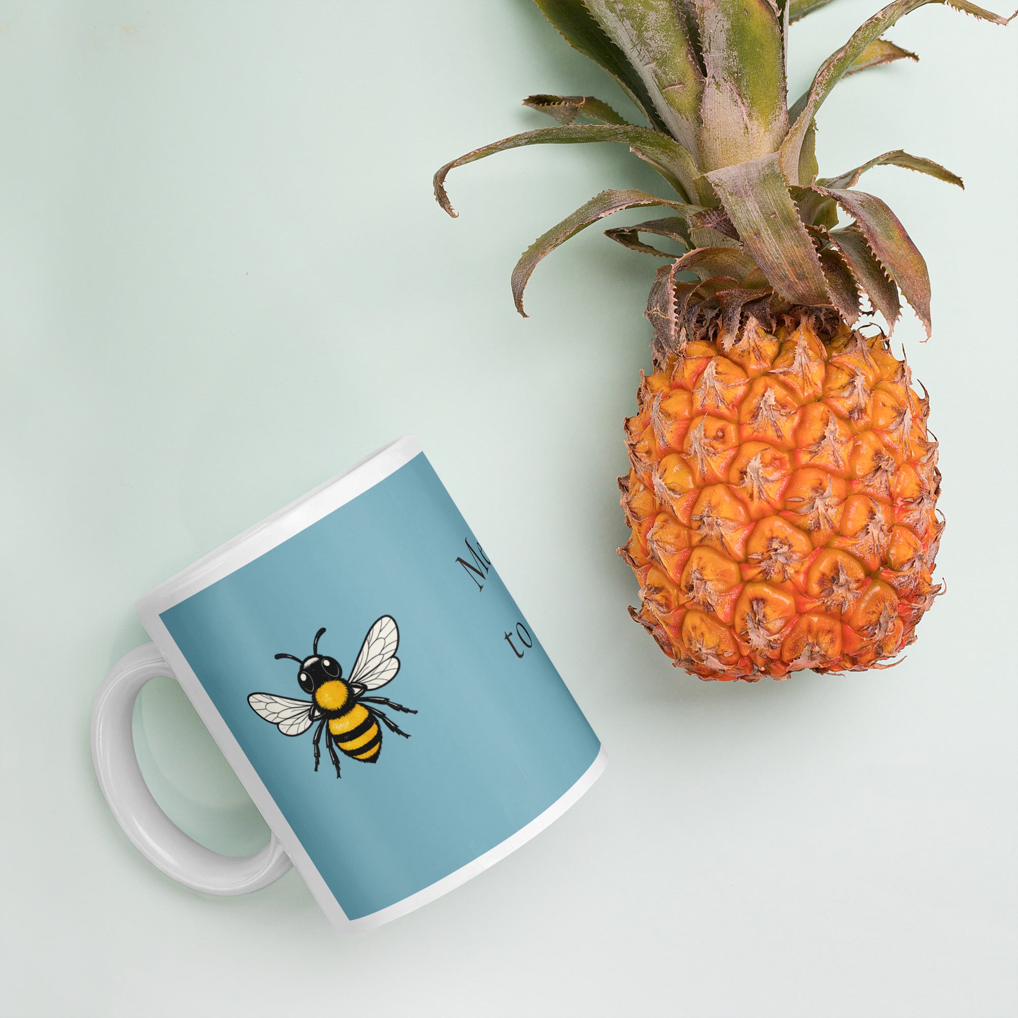 Blue ceramic coffee mug with bee illustration, angled view on tabletop.