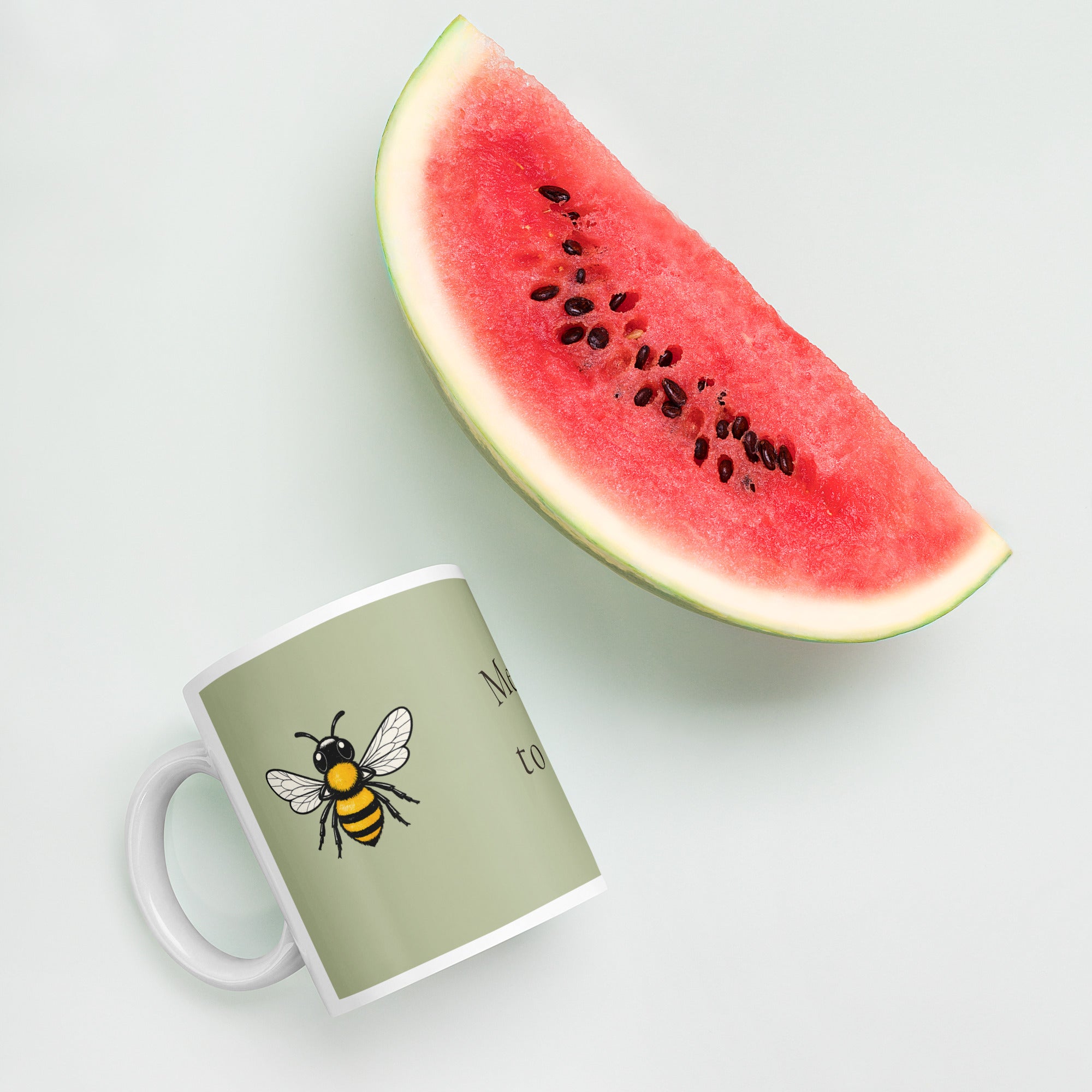 Sage green ceramic coffee mug with bee illustration and white handle