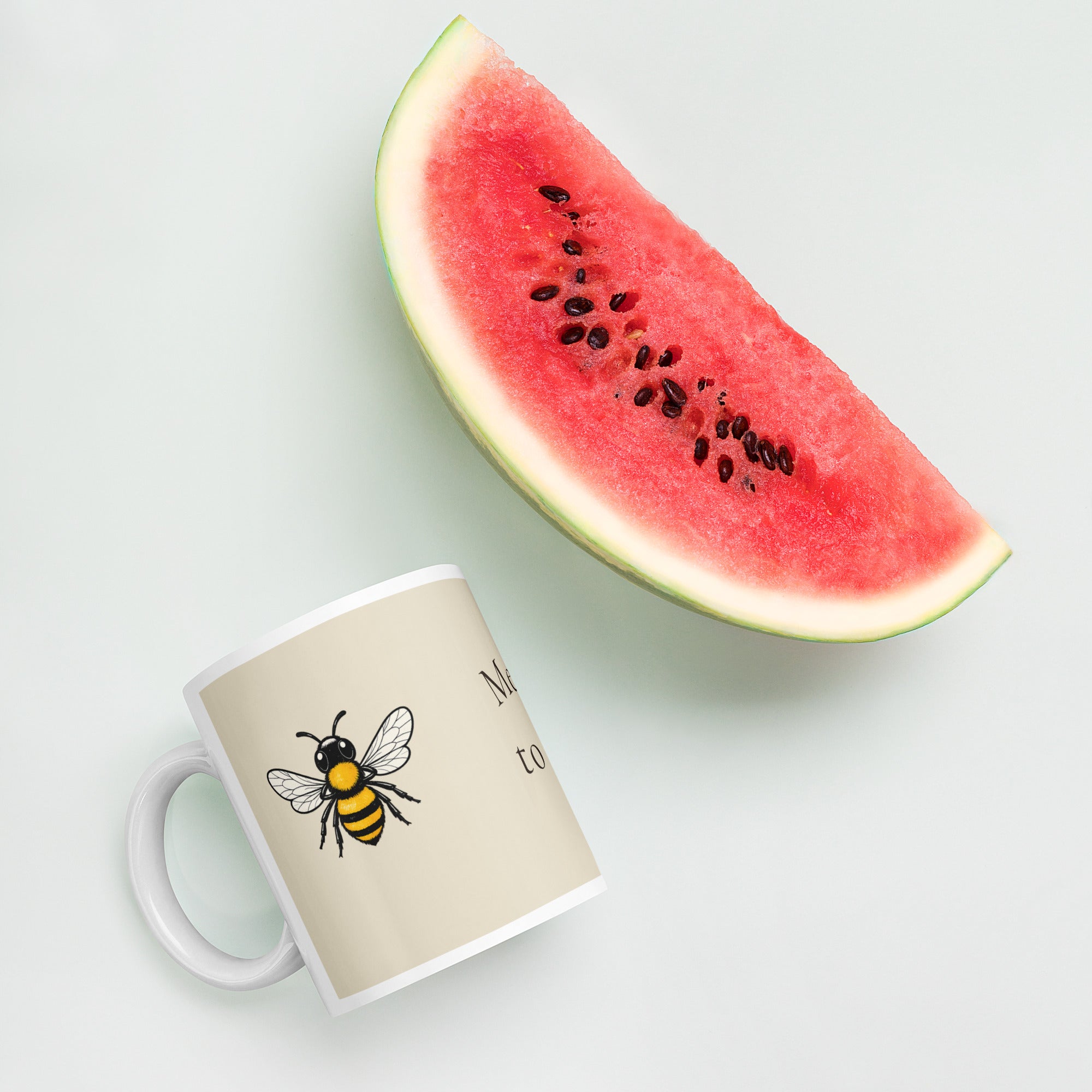 Light beige ceramic mug with bee illustration, white rim, and white handle