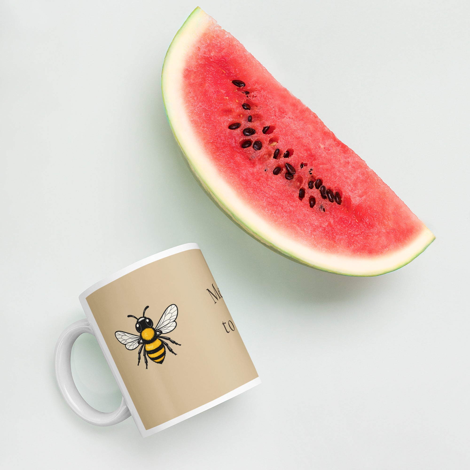 Beige ceramic coffee mug with bee illustration and white handle