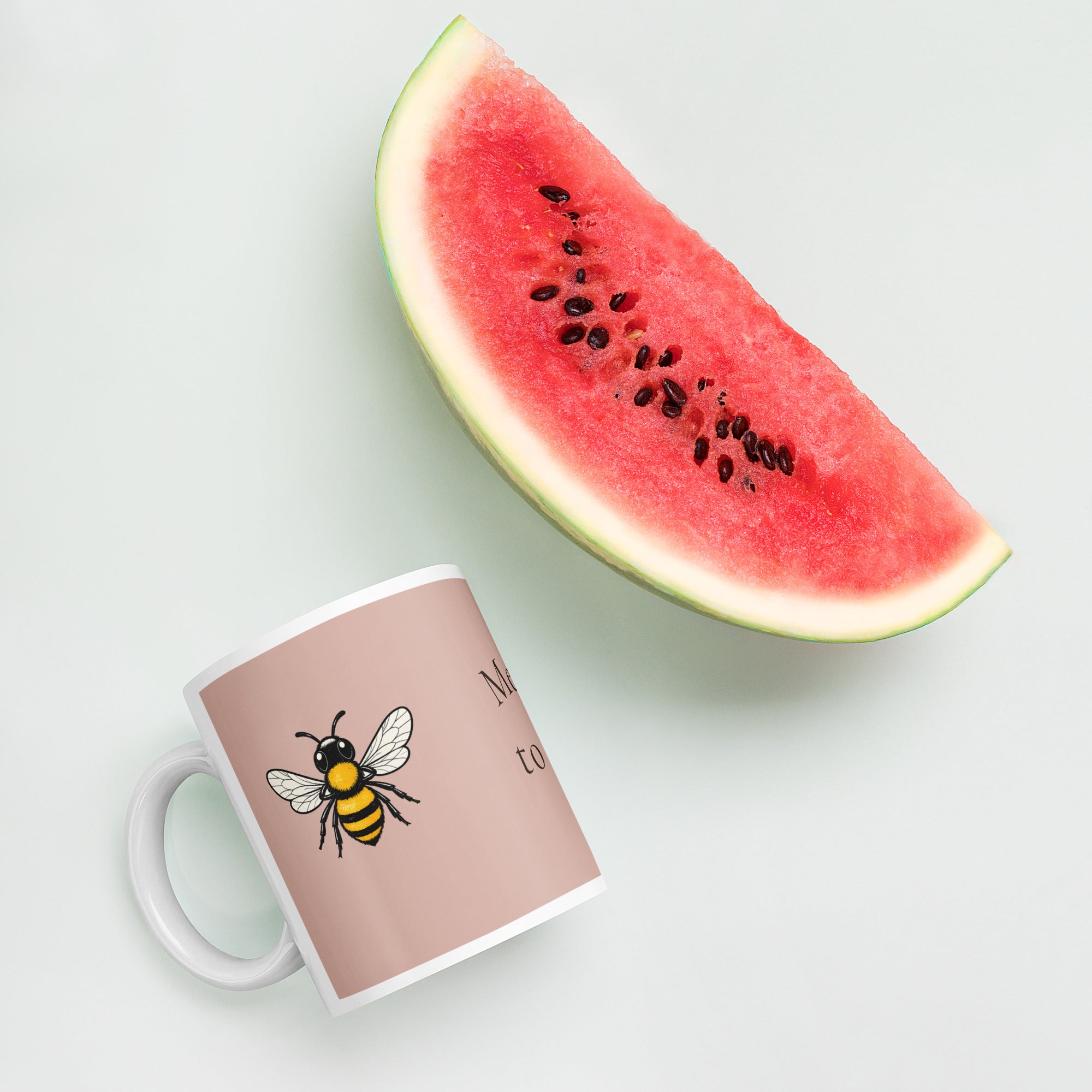 Dusty rose ceramic coffee mug, white handle and rim, with bee illustration