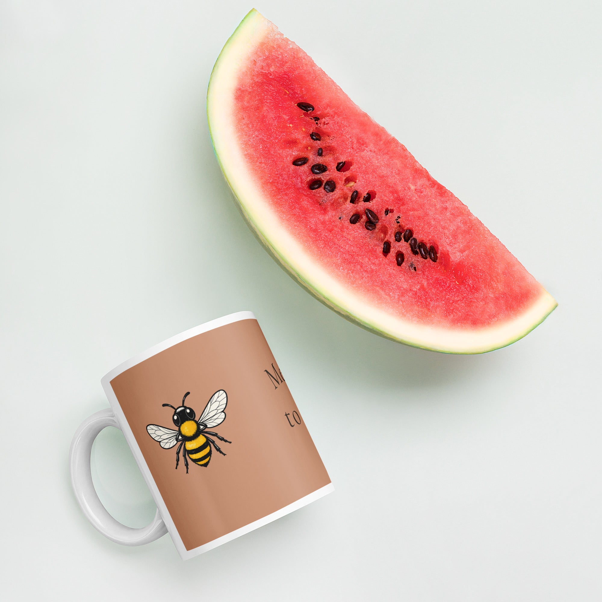 Brown ceramic mug with white handle and rim, bee illustration on the side