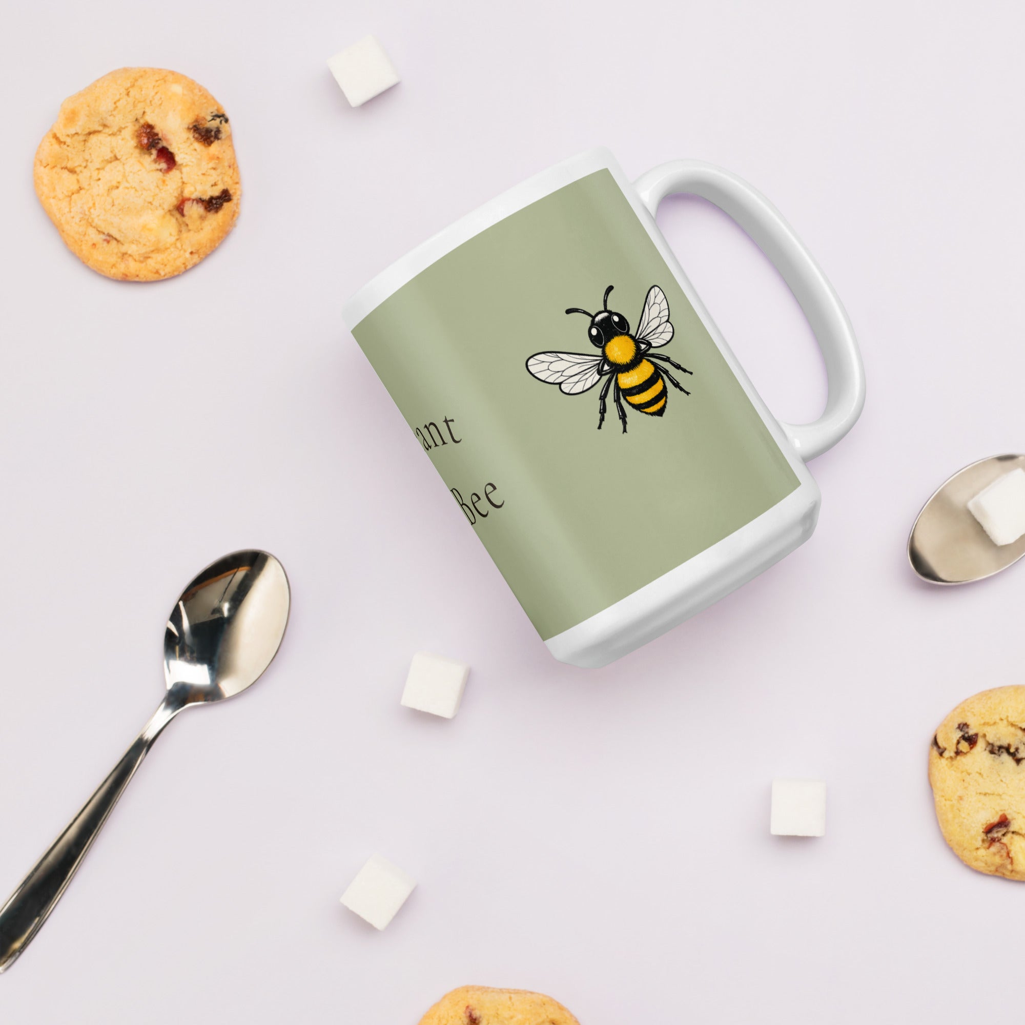 Sage green ceramic coffee mug with bee illustration, angled overhead with handle