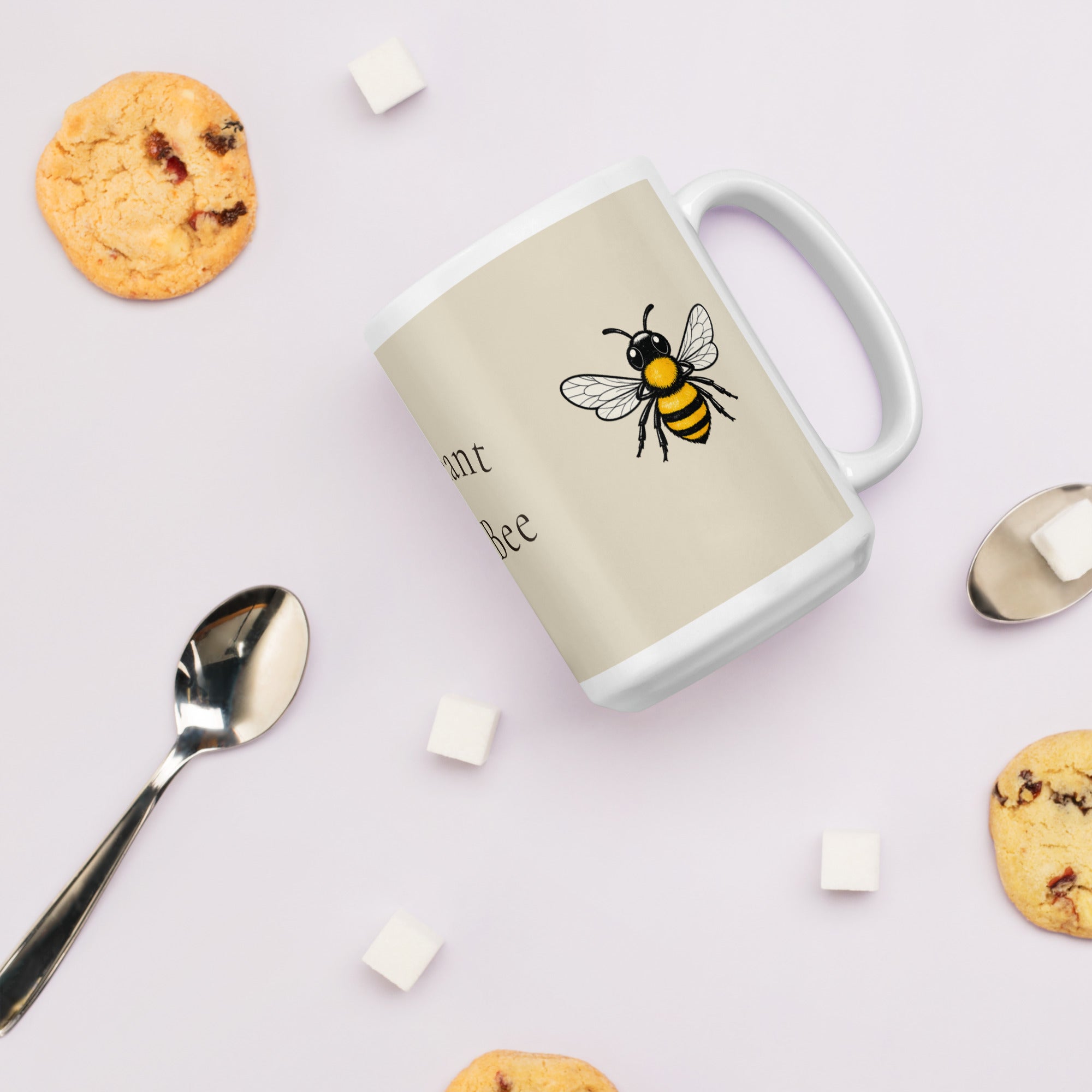 Light beige ceramic mug with bee graphic and partial text on side, white handle