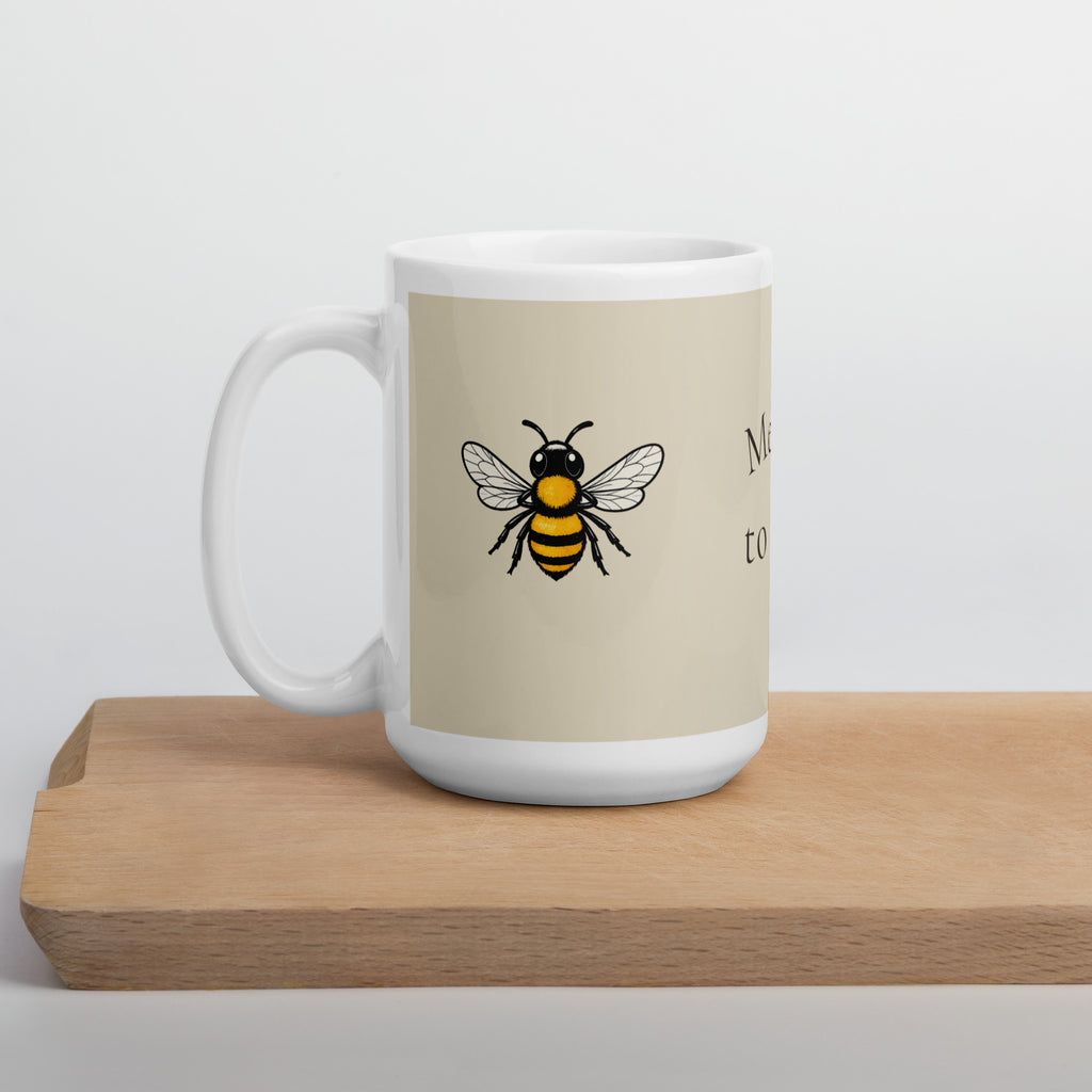 Light beige ceramic coffee mug with bee illustration on front and white base