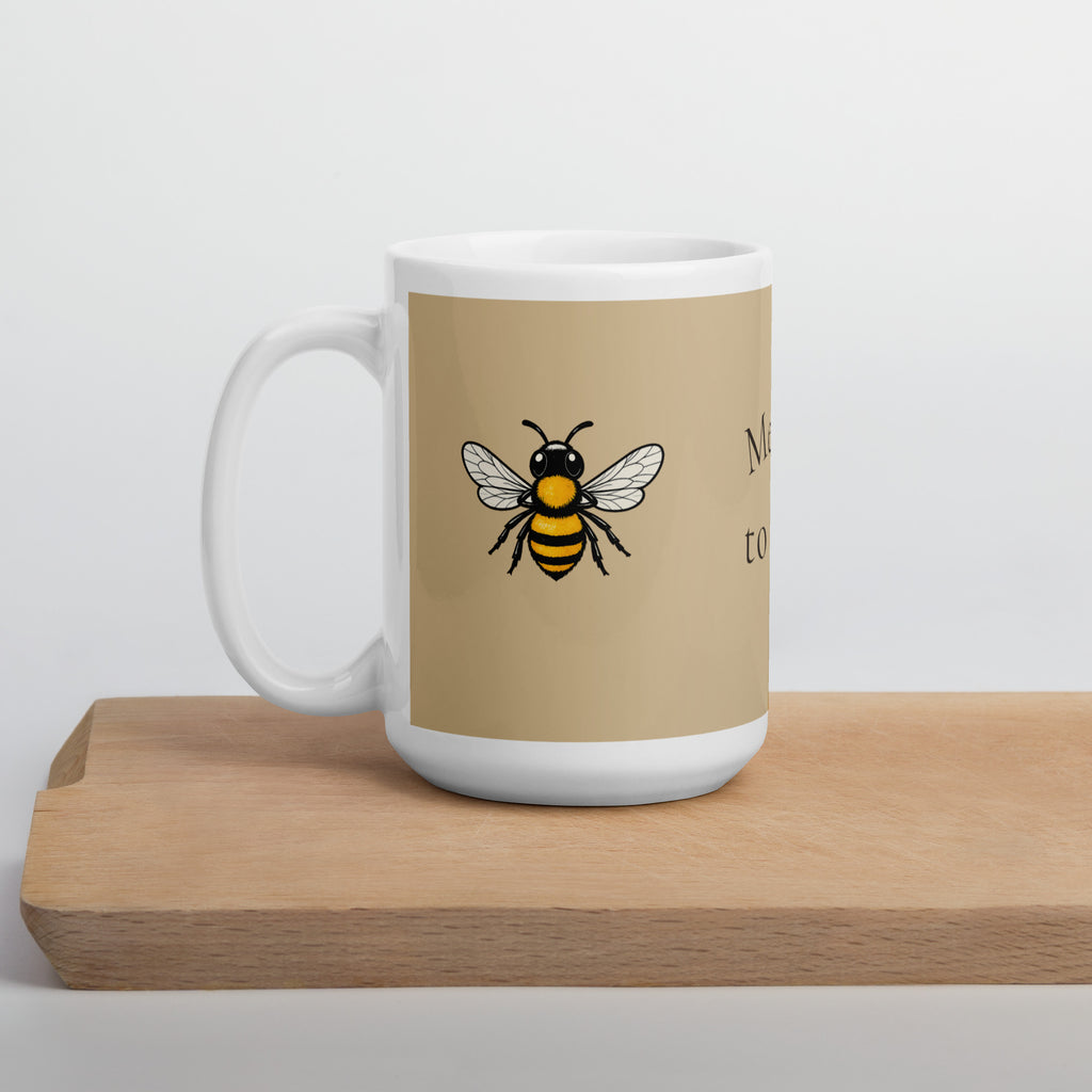 Beige ceramic mug with bee illustration on front and white handle