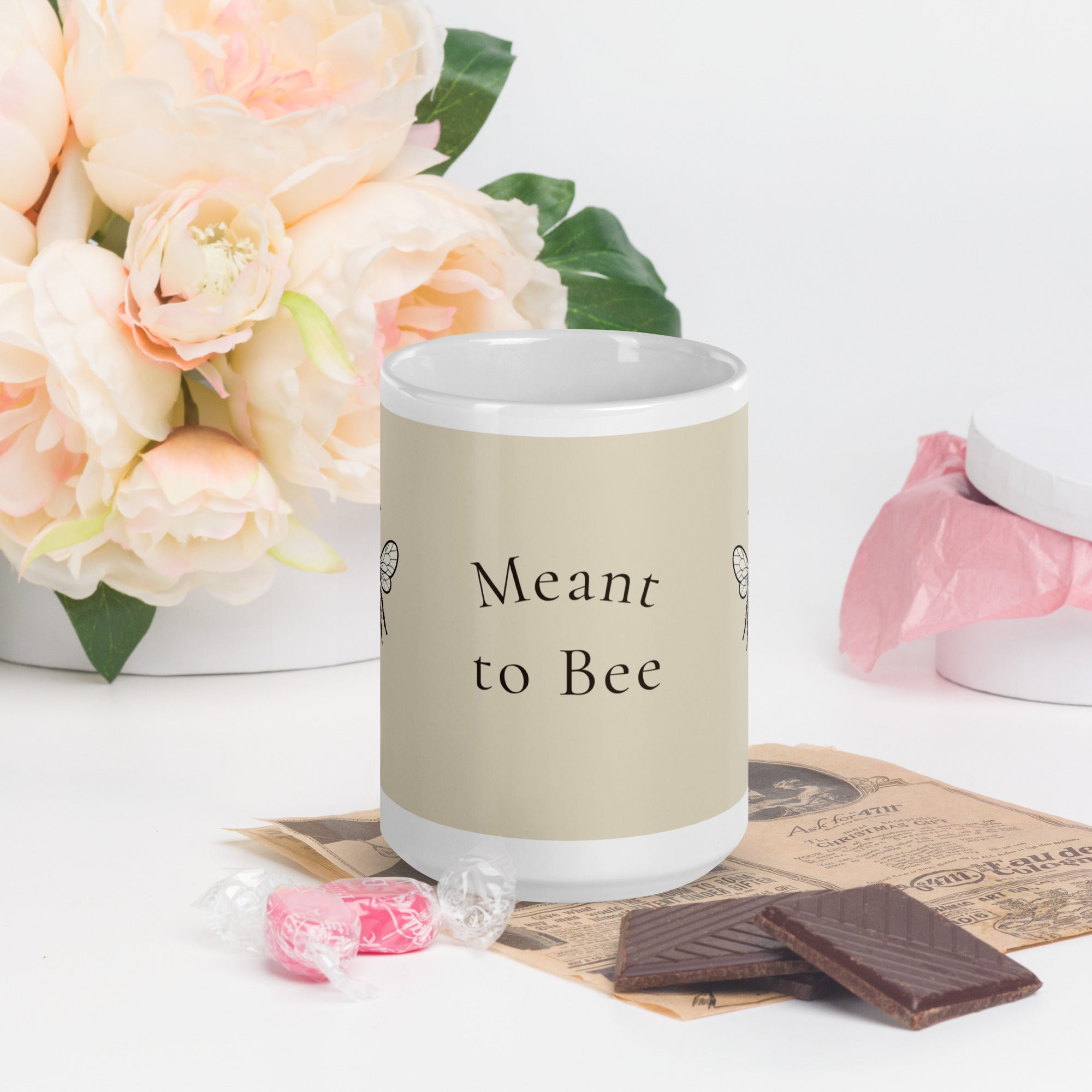 Light beige ceramic mug showing 'Meant to Bee' text and white rim