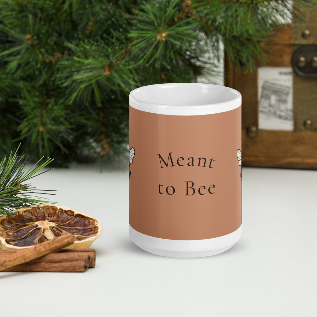 Brown ceramic mug with "Meant to Bee" lettering, white rim and handle