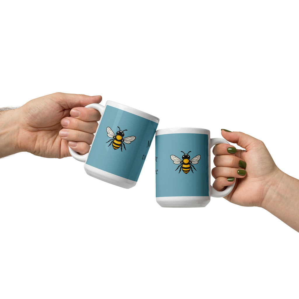 Pair of blue ceramic coffee mugs with bee illustrations, white rims and handles