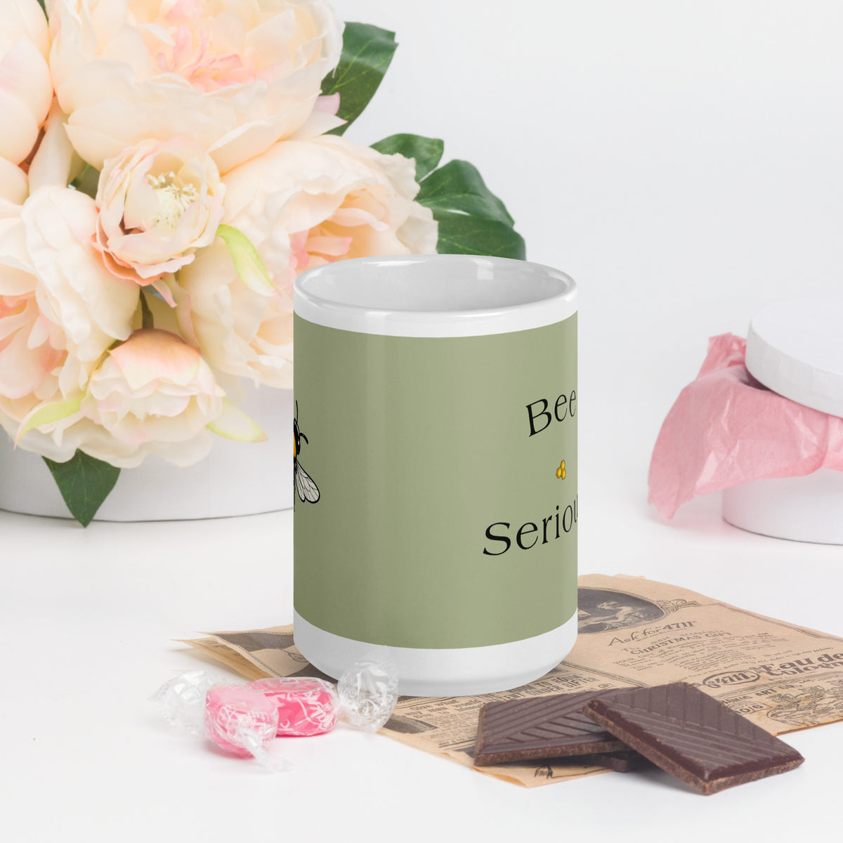 Ceramic coffee mug, green with partial 'Bee Serious' lettering; white handle