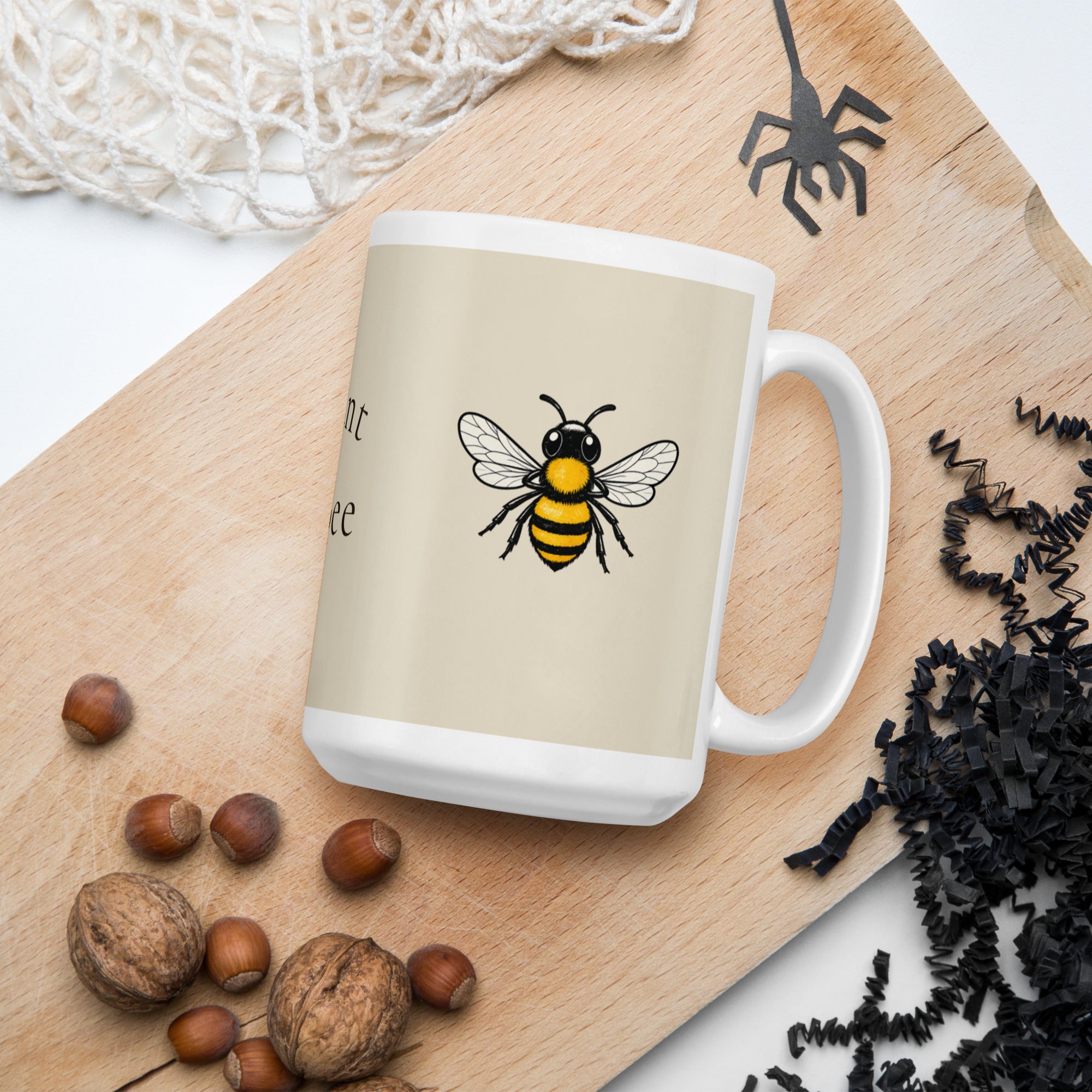 Light beige ceramic coffee mug with bee illustration on side, slightly angled