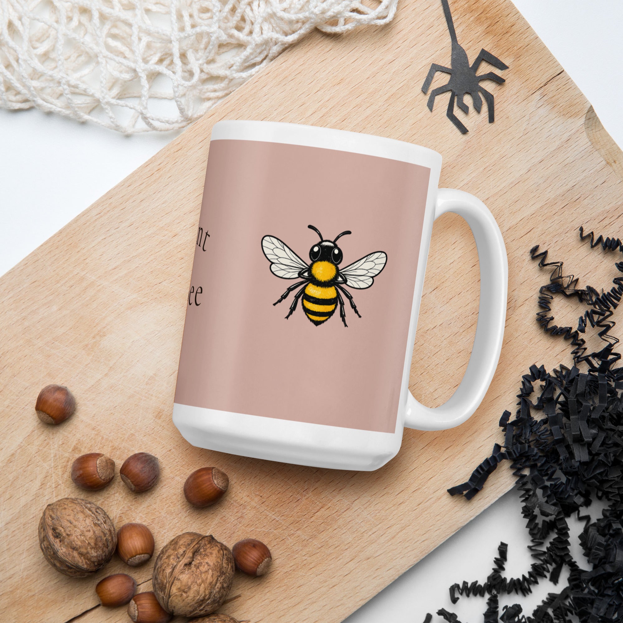 Dusty rose ceramic mug with white handle and rim, showing a bee illustration