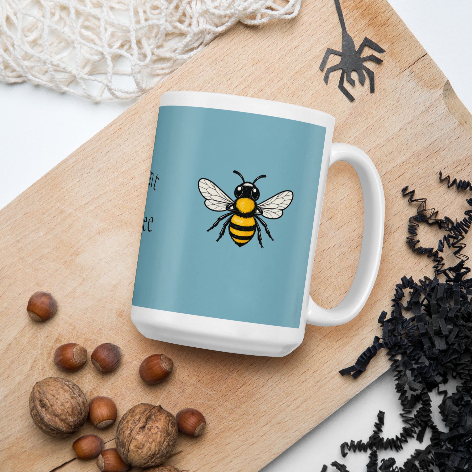 Blue ceramic coffee mug with white handle and a bee illustration on the front