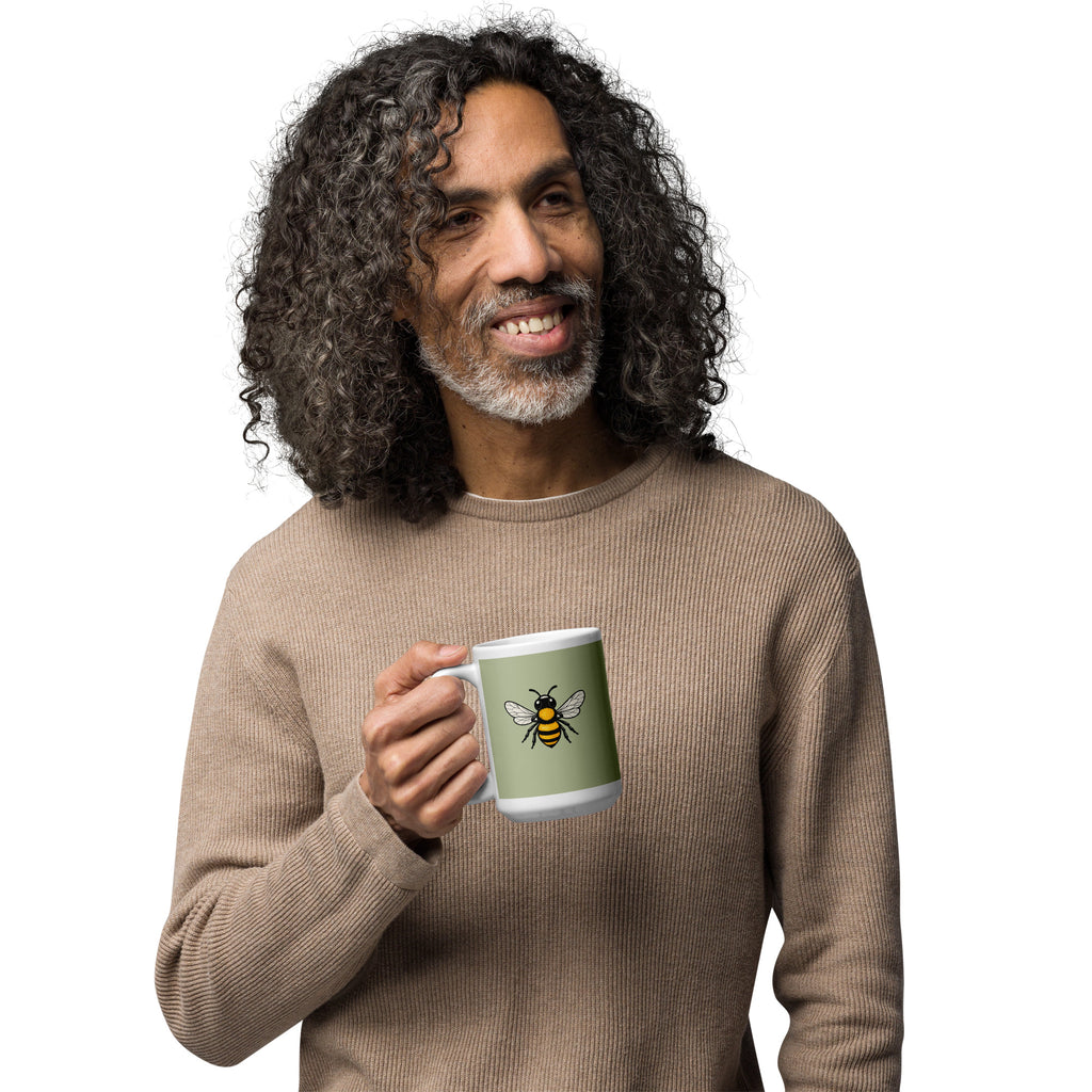 Ceramic coffee mug with green front and centered bee illustration