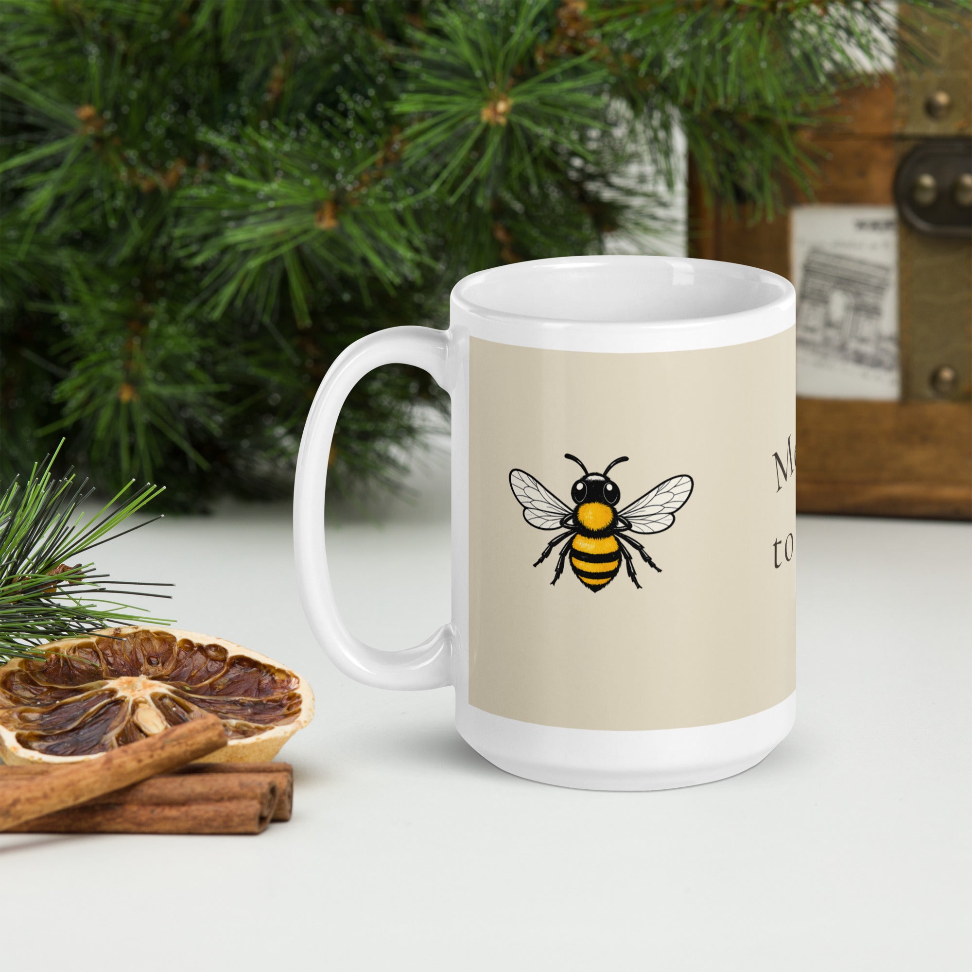 Light beige ceramic coffee mug with white handle, bee illustration on front