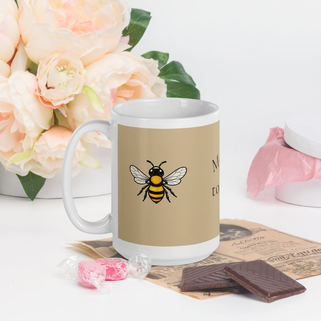 Beige ceramic coffee mug with bee illustration and white C-handle