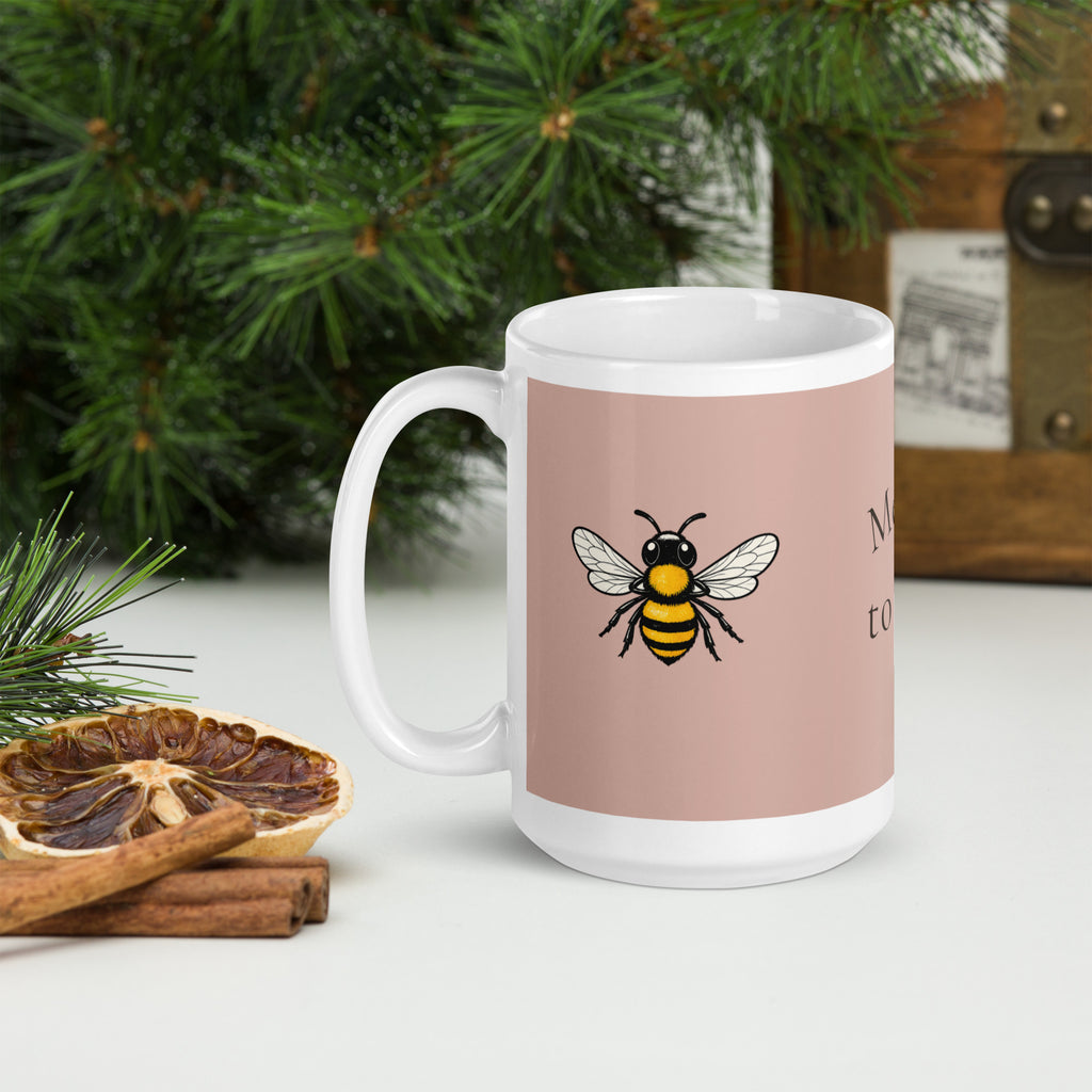 Dusty rose ceramic mug with white handle, rim, and bee illustration on front