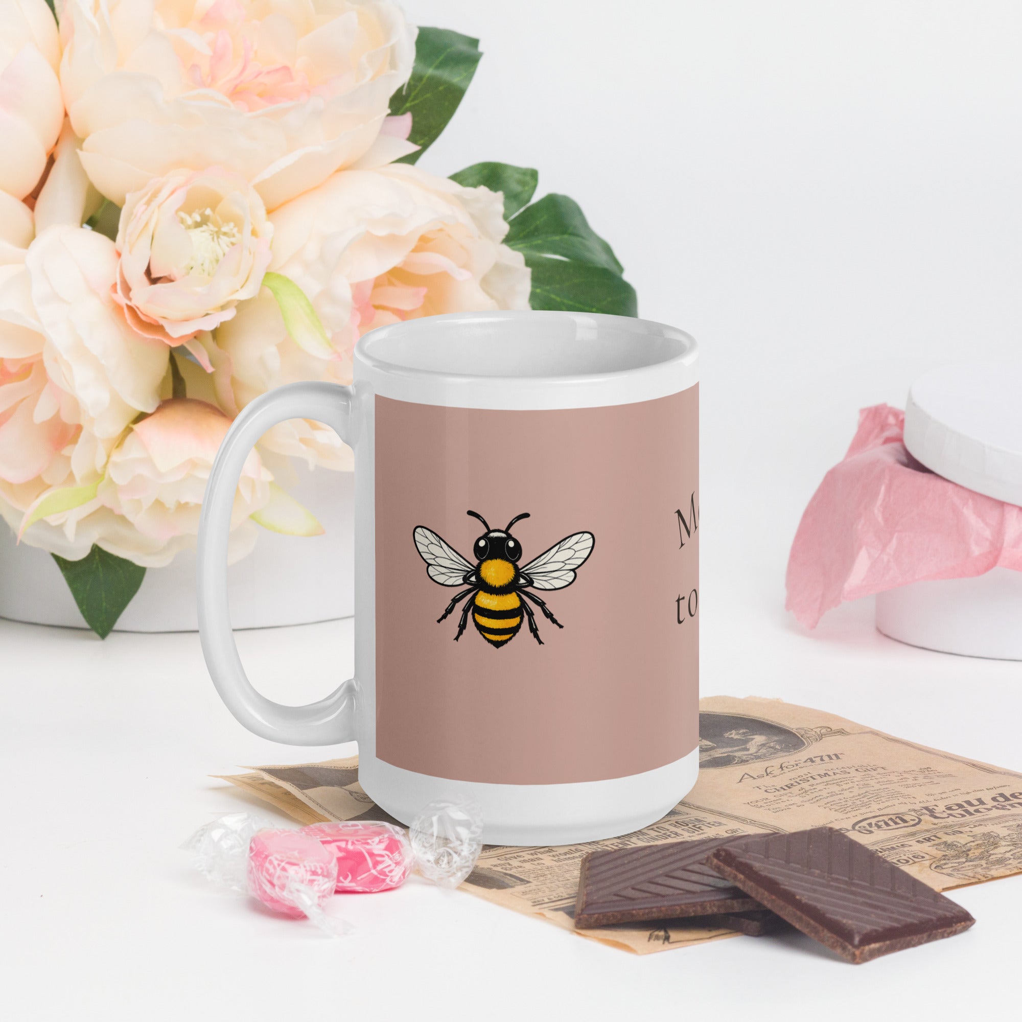 Dusty rose ceramic coffee mug with bee illustration, front view with handle.
