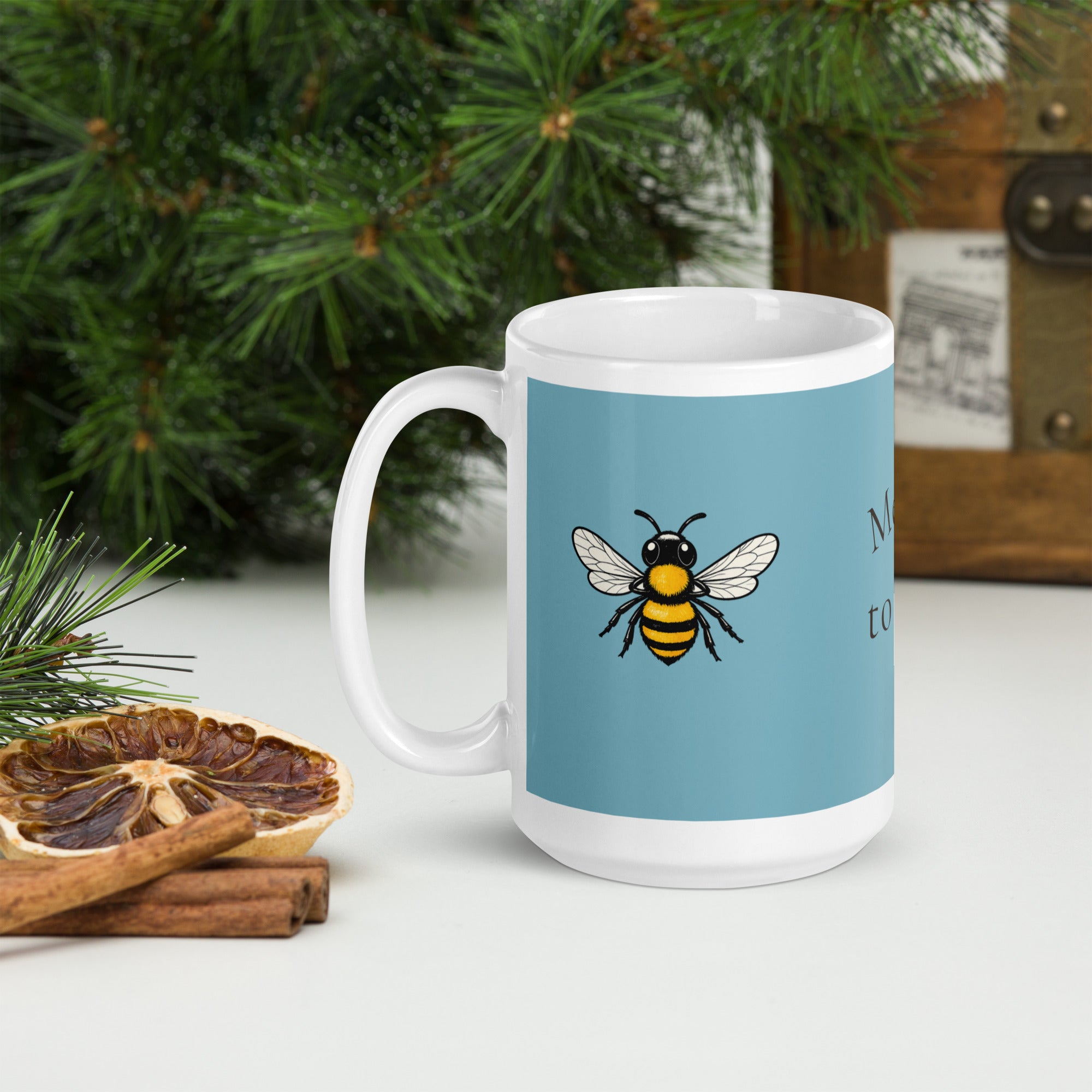 Blue ceramic mug with white handle and bee illustration, angled view