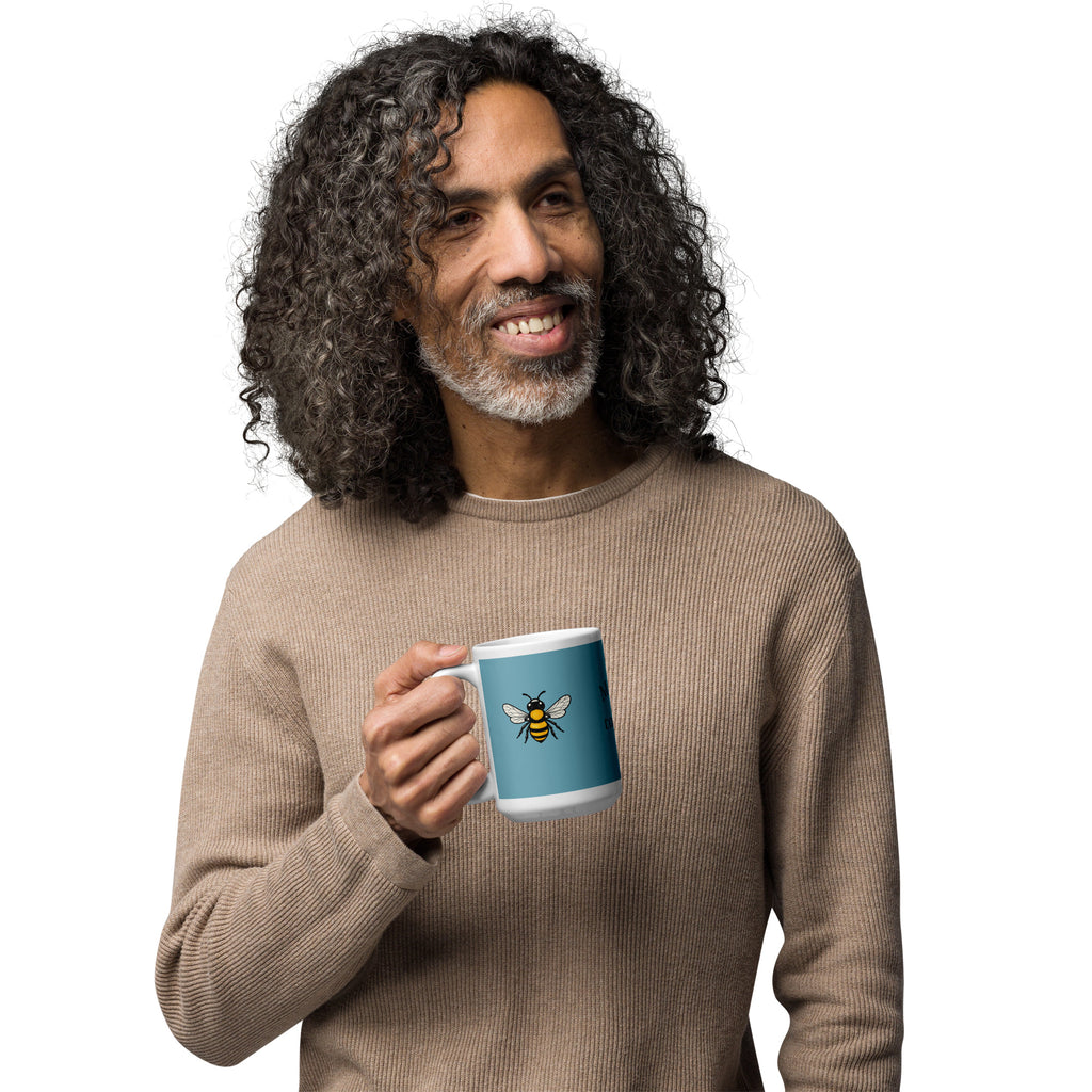 Blue ceramic coffee mug with bee illustration on front, white rim and curved handle