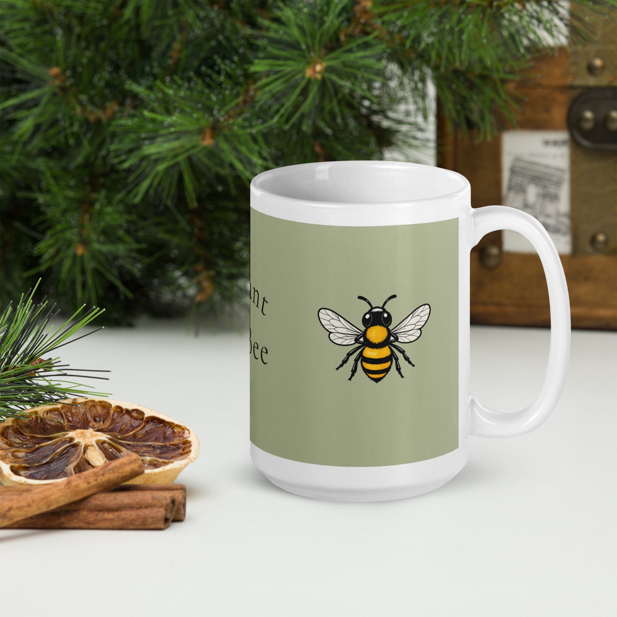 Sage green ceramic mug with bee illustration and white handle, angled front view