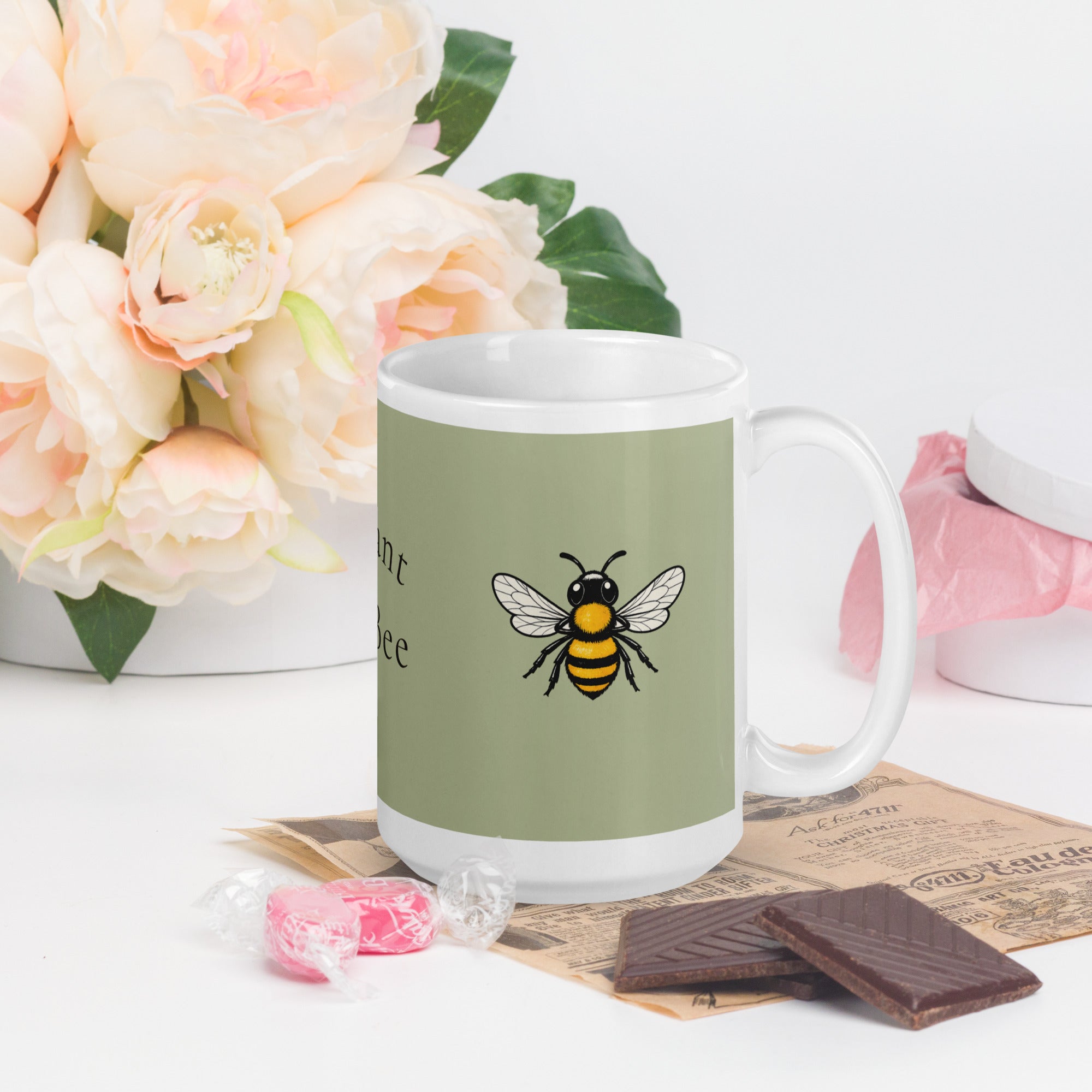 Sage green ceramic mug with white handle and centered bee illustration