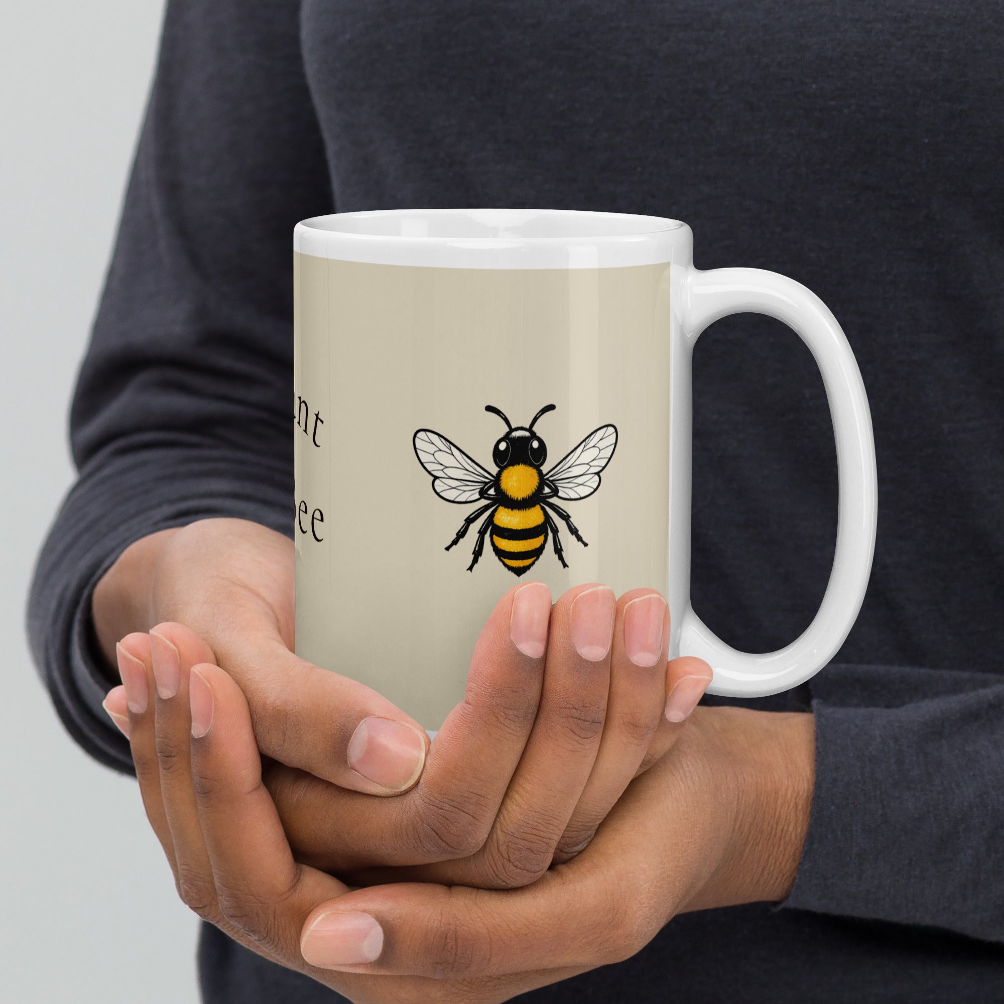 Light beige ceramic mug with bee illustration on front, held in hands
