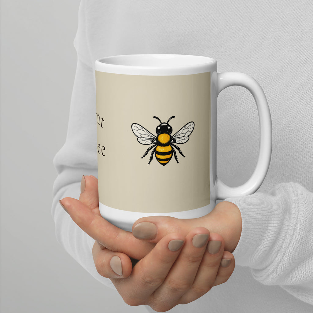 Light beige ceramic mug with bee illustration on front and white handle