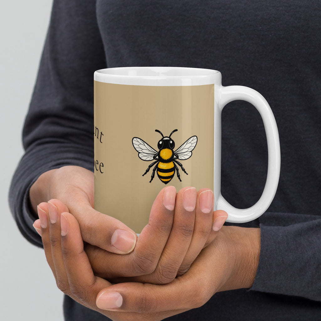 Beige ceramic coffee mug with white handle, featuring a bee illustration on the front