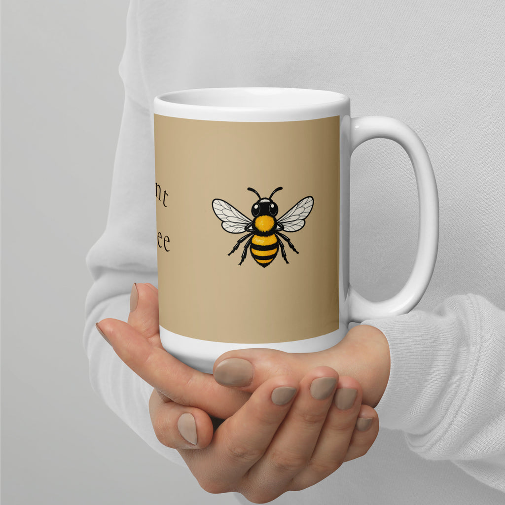 Beige ceramic coffee mug with white handle, yellow-and-black bee illustration in center