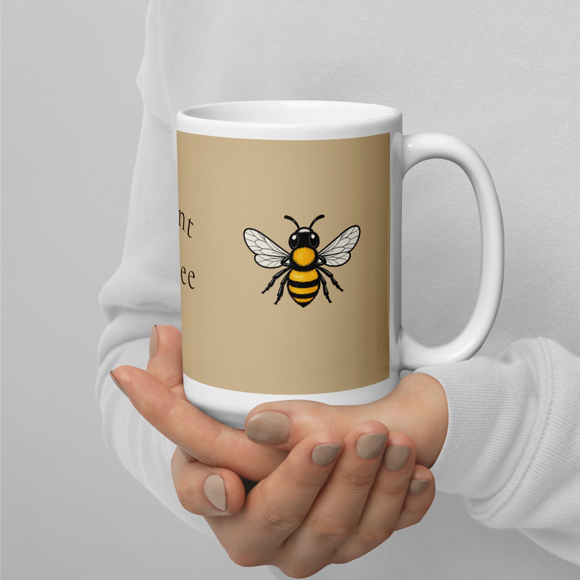 Beige ceramic coffee mug with white handle, yellow-and-black bee illustration in center
