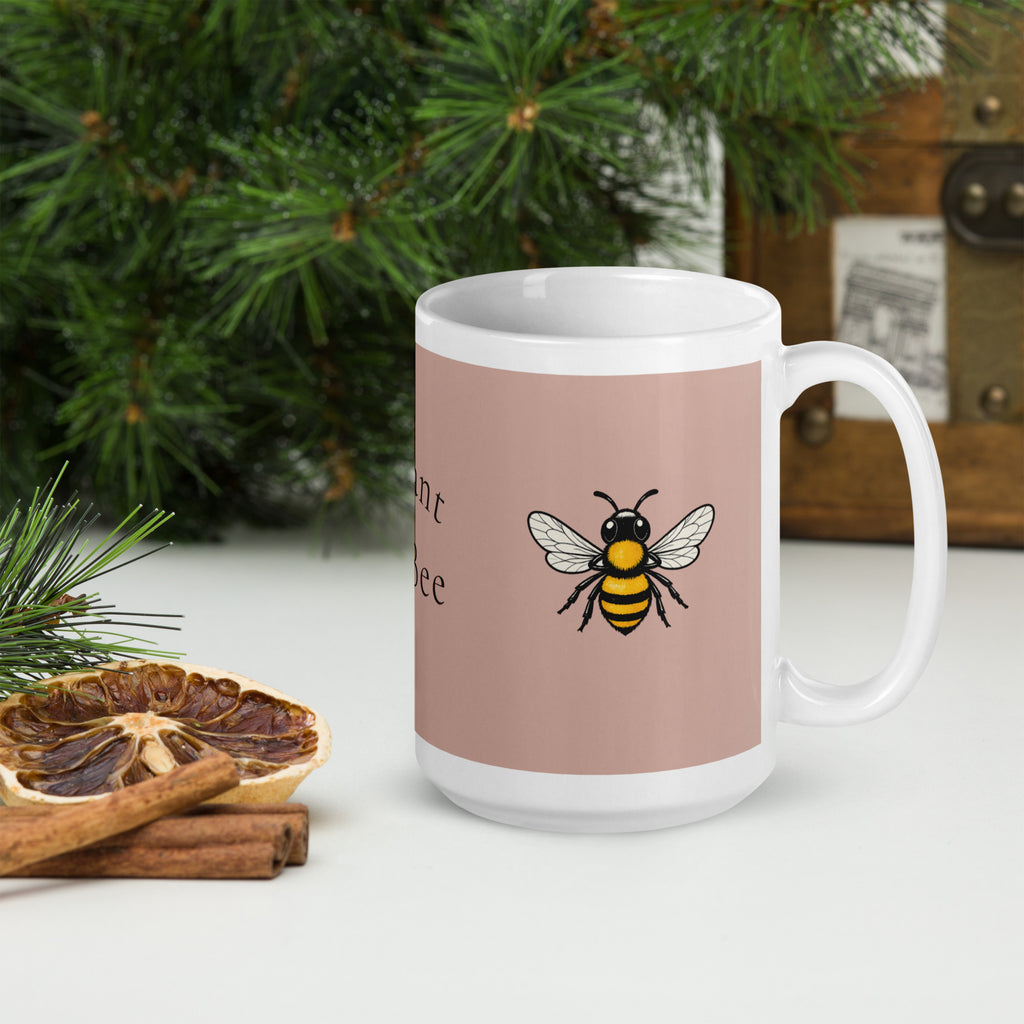 Dusty rose ceramic coffee mug with white rim and bee illustration on front.