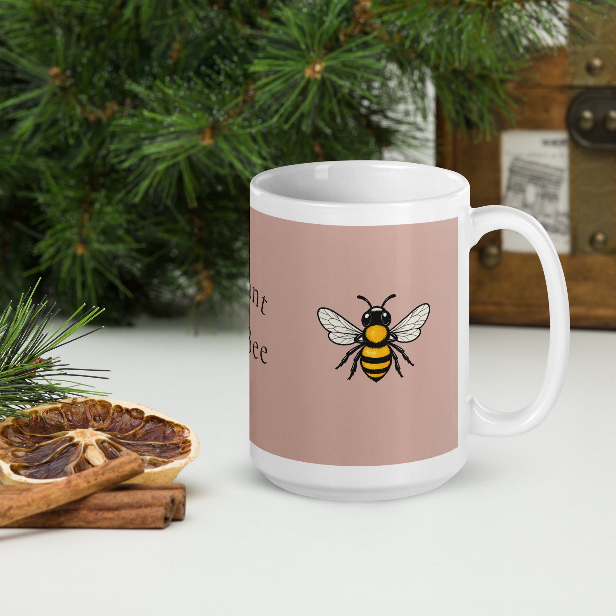 Dusty rose ceramic coffee mug with white rim and bee illustration on front.