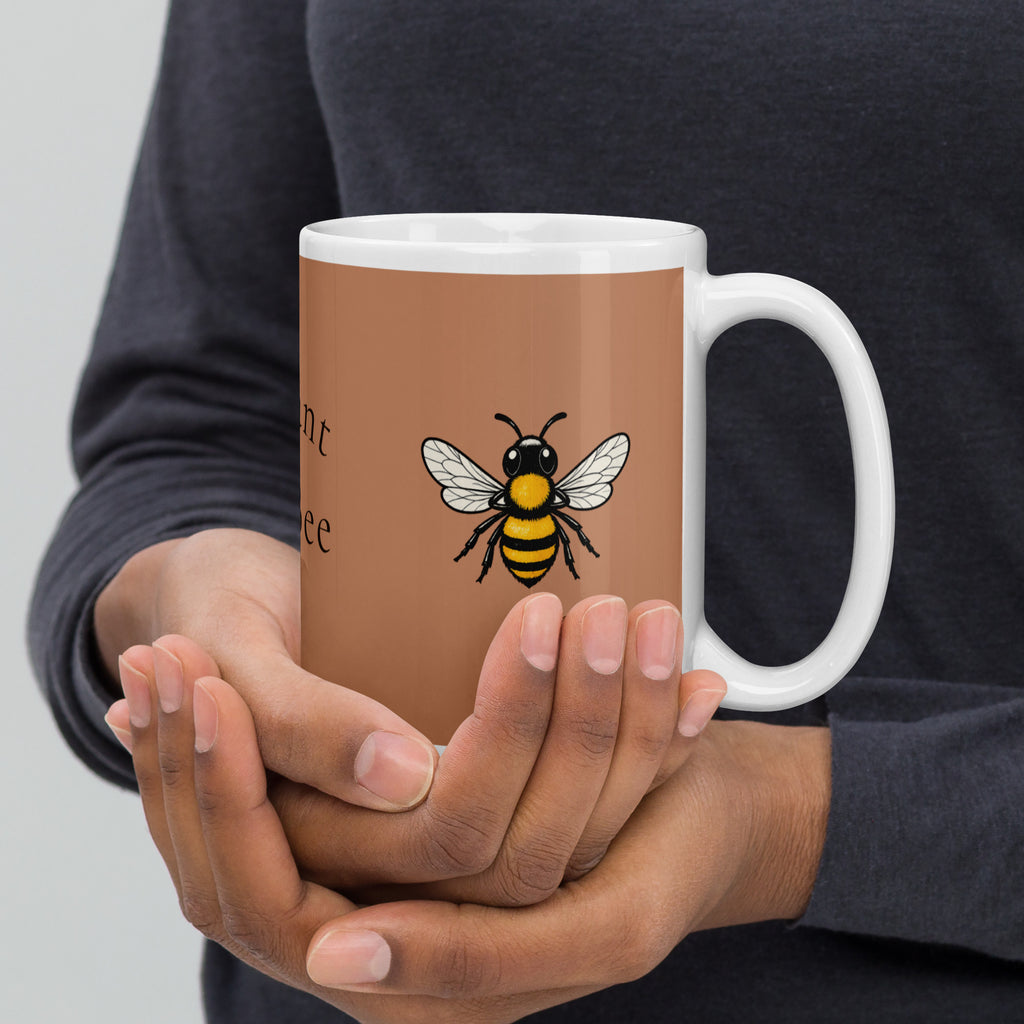 Brown ceramic mug with bee illustration and white handle, held close