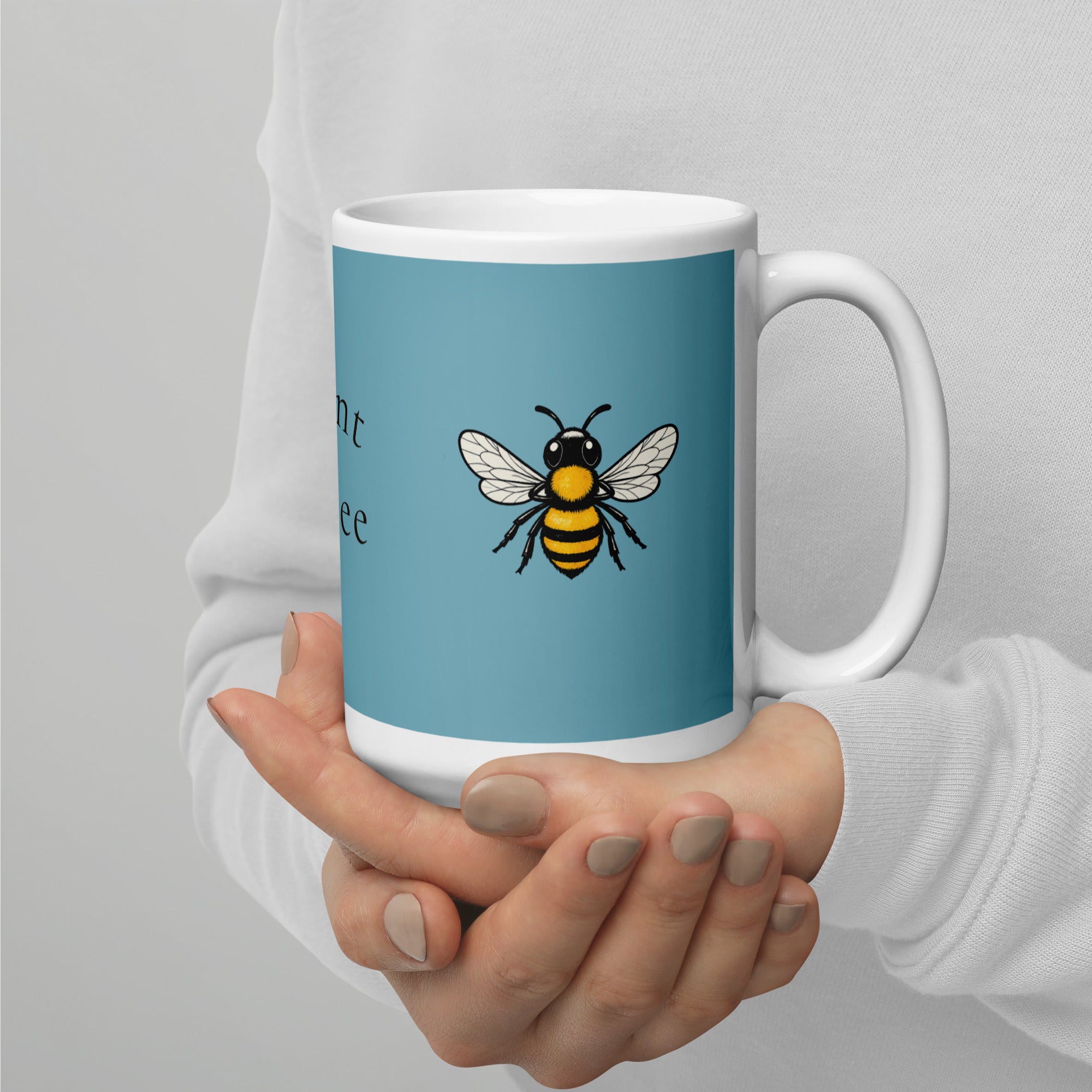 Blue ceramic coffee mug with bee illustration and white rim and handle