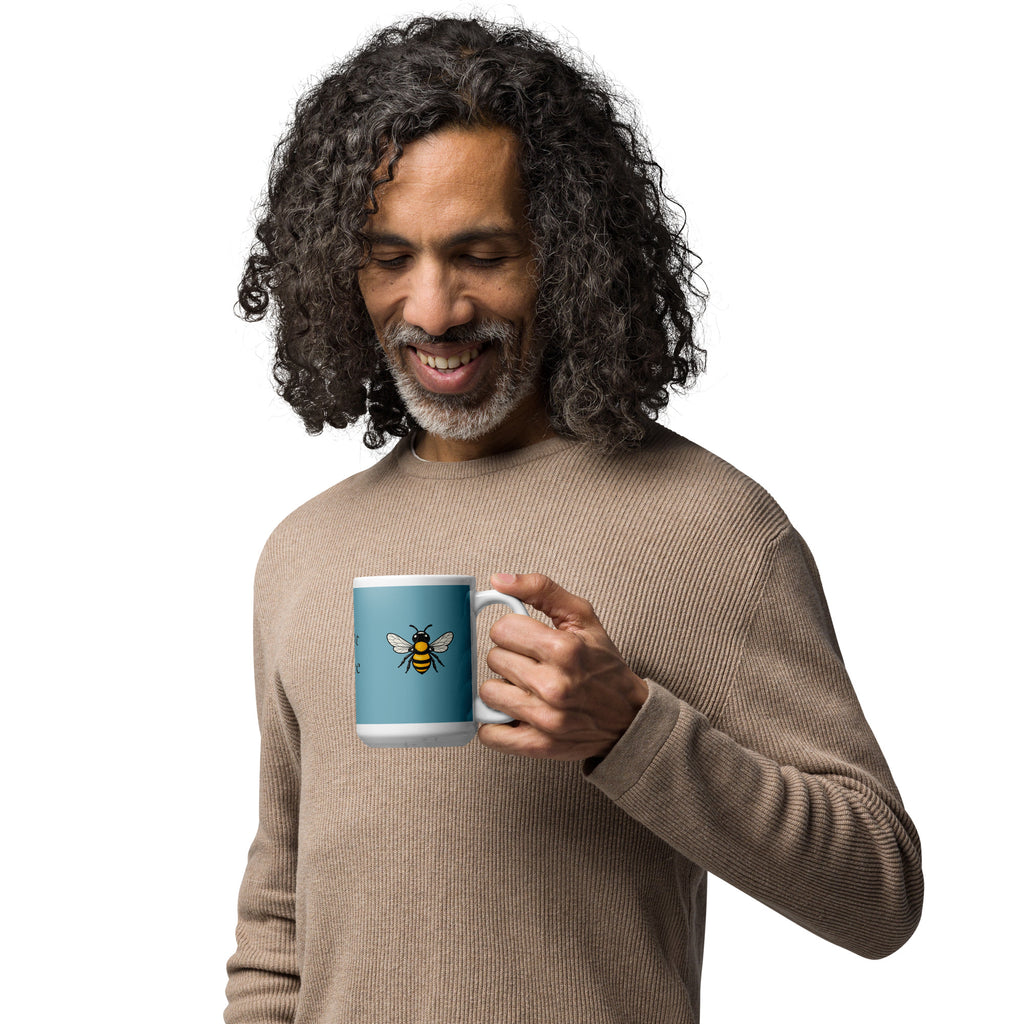 Blue ceramic coffee mug with bee illustration on front, white rim and handle