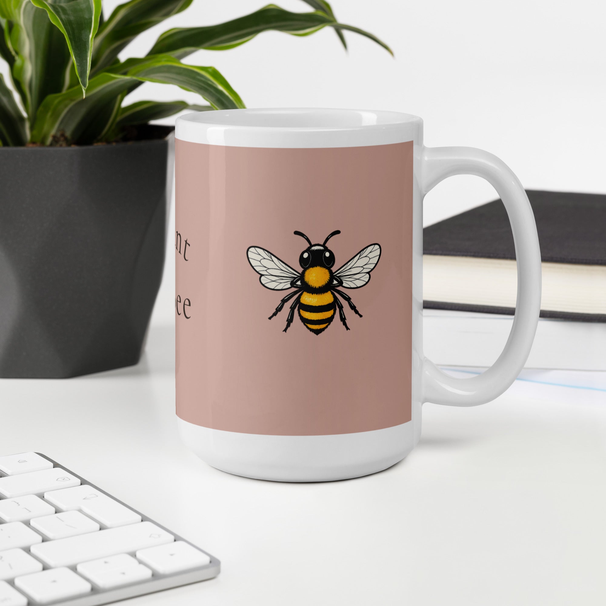 Dusty rose ceramic coffee mug with centered bee graphic; white handle and rim.