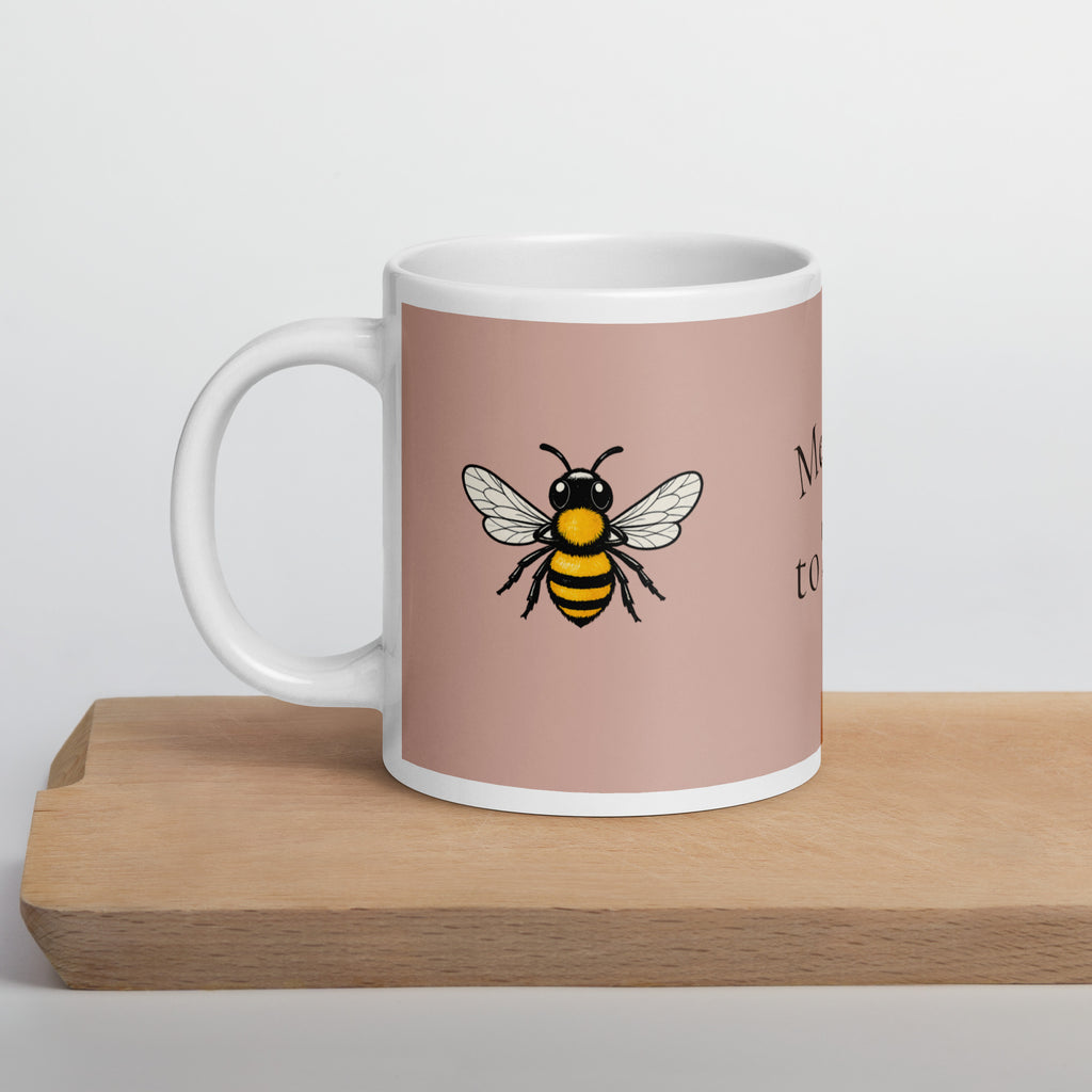 Dusty rose ceramic mug with white rim and handle, featuring a centered bee illustration