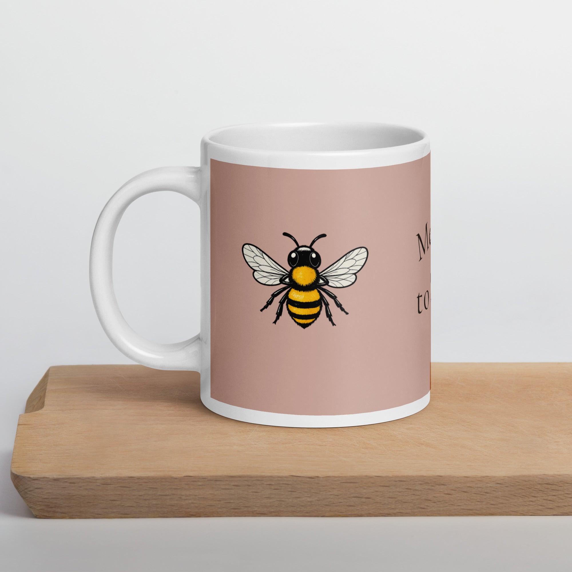 Dusty rose ceramic mug with white rim and handle, featuring a centered bee illustration