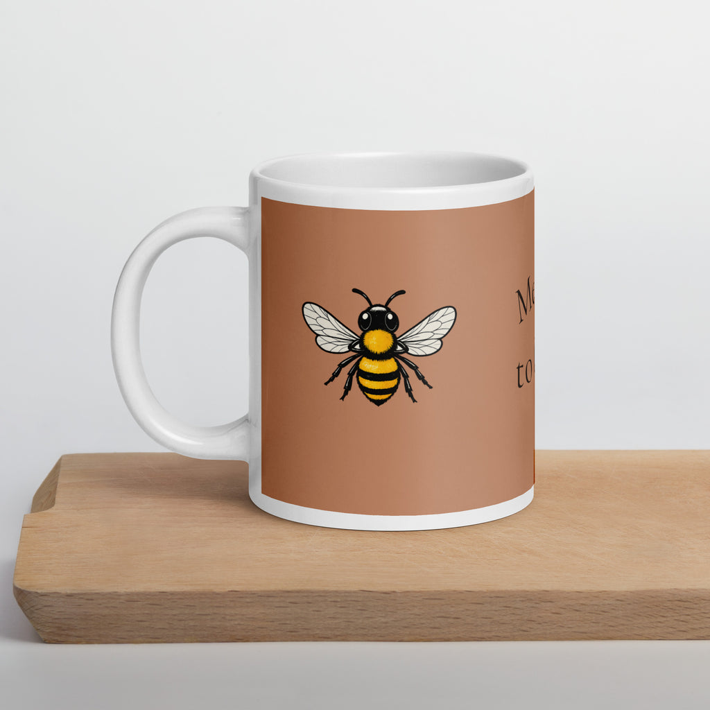 Brown ceramic coffee mug with white rim and handle, yellow bee illustration