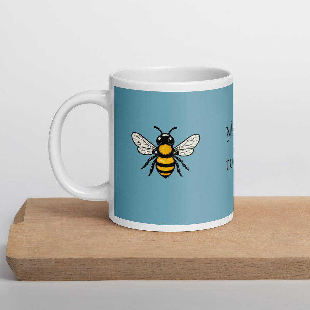 Blue ceramic coffee mug with centered bee illustration, white handle
