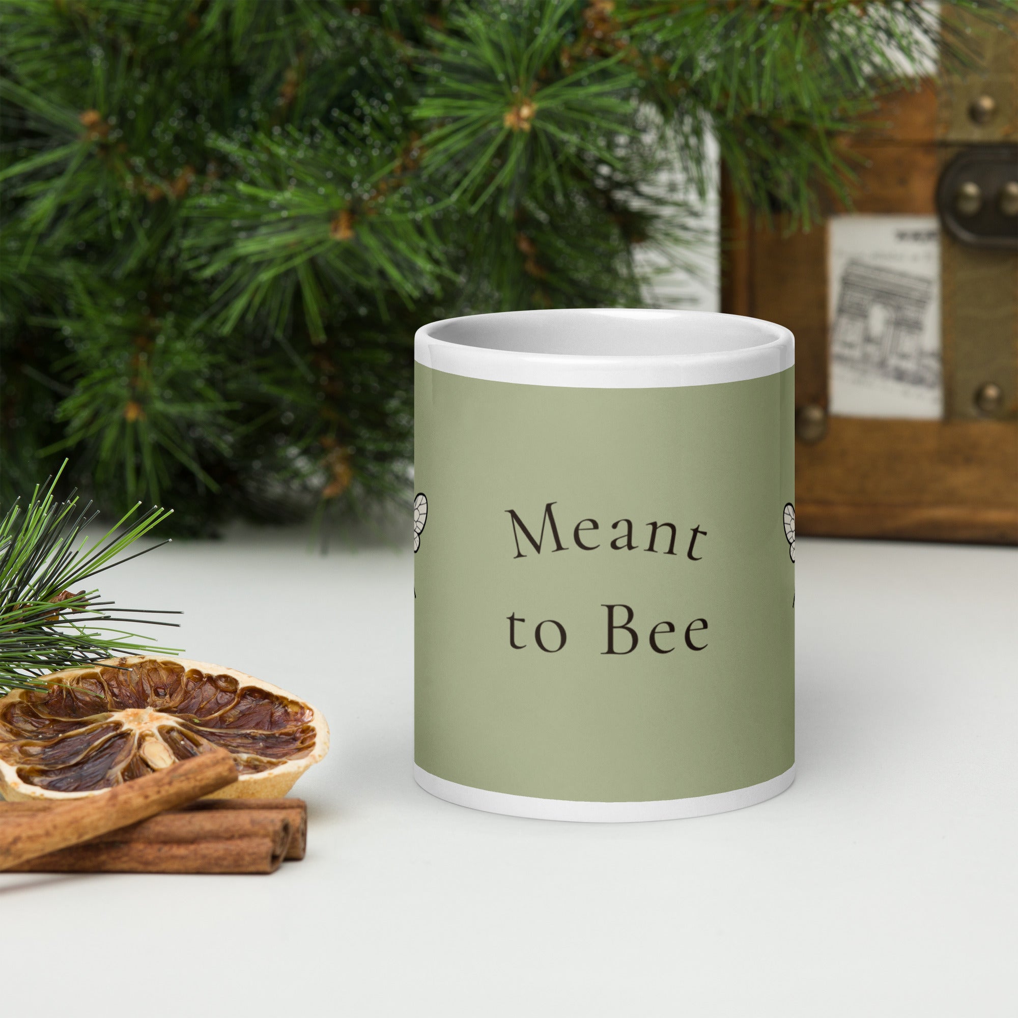 Sage green ceramic coffee mug with white handle, “Meant to Bee” text on front