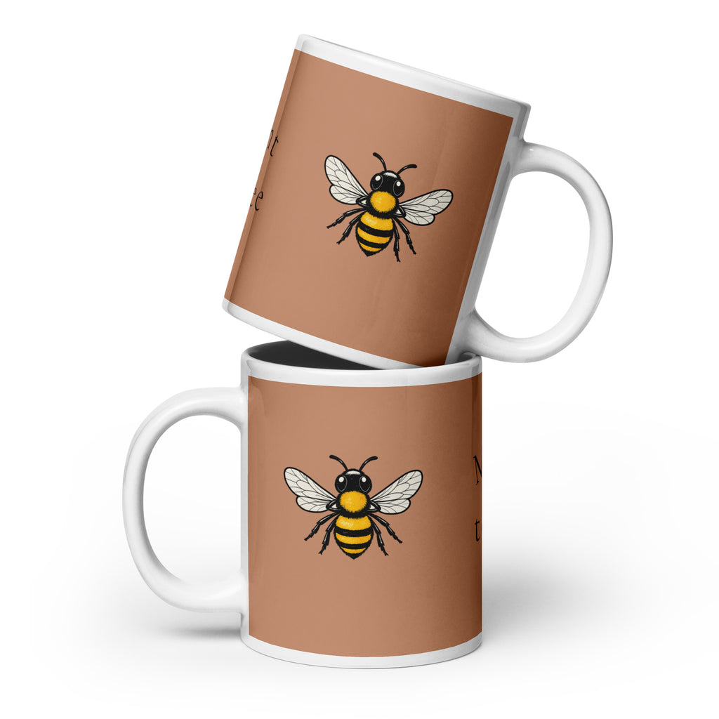 Stacked brown ceramic coffee mugs with bee illustrations and white handles