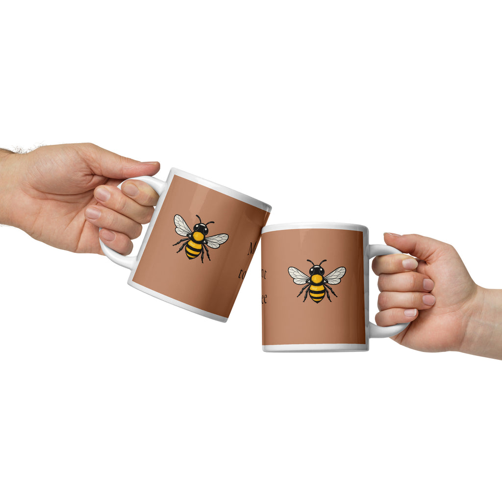 Brown ceramic coffee mug with white rim and handle, featuring a yellow and black bee