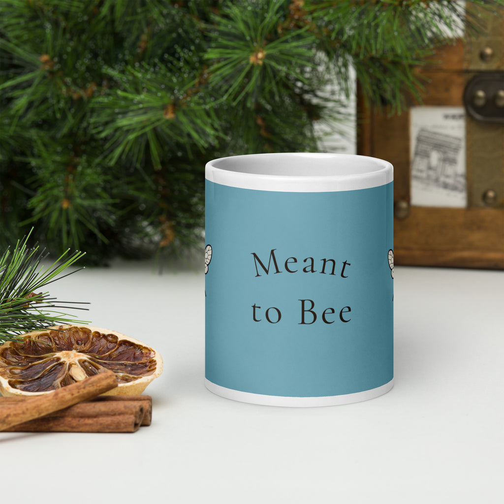 Blue ceramic coffee mug with 'Meant to Bee' text, white rim and handle.
