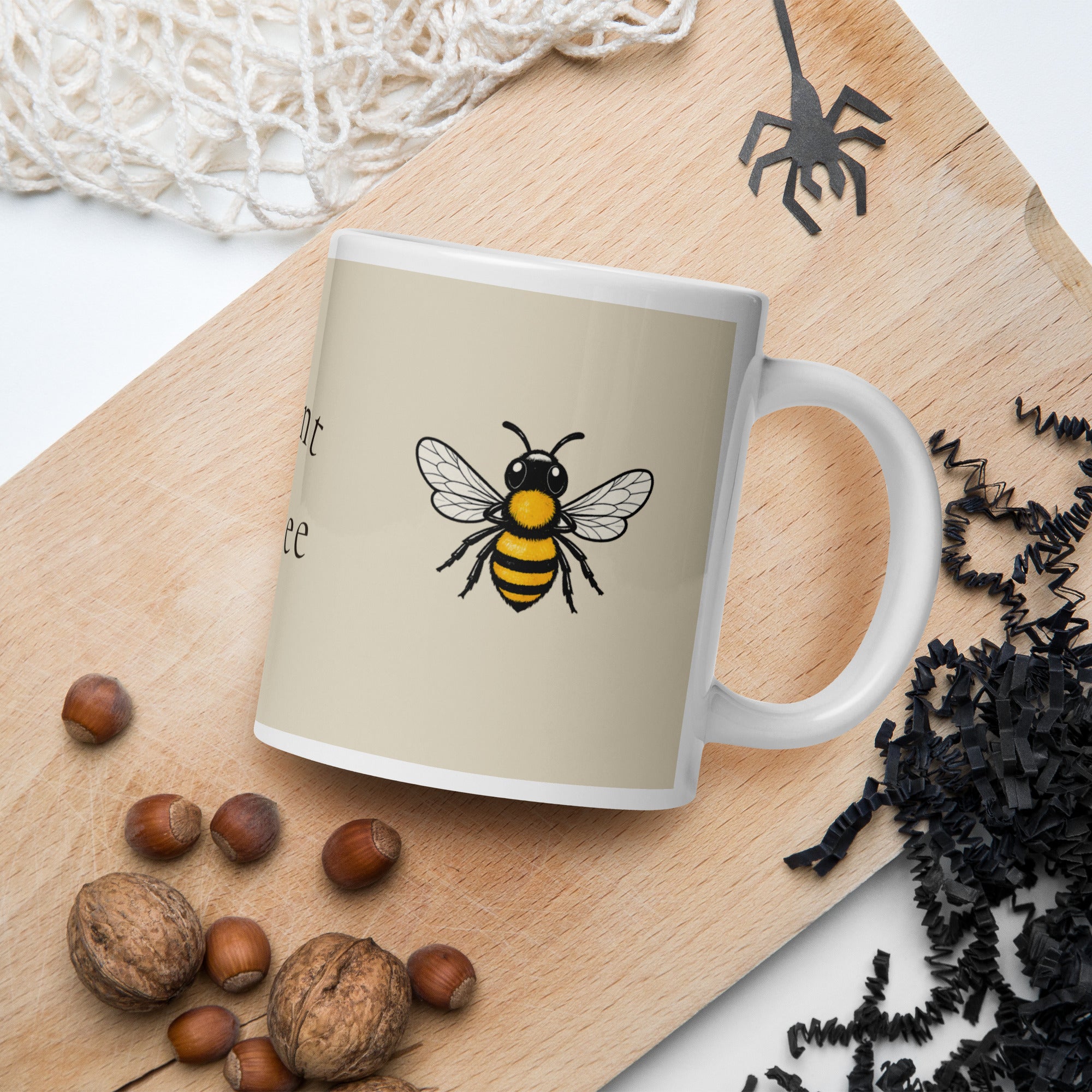 Light beige ceramic coffee cup with bee illustration and white handle