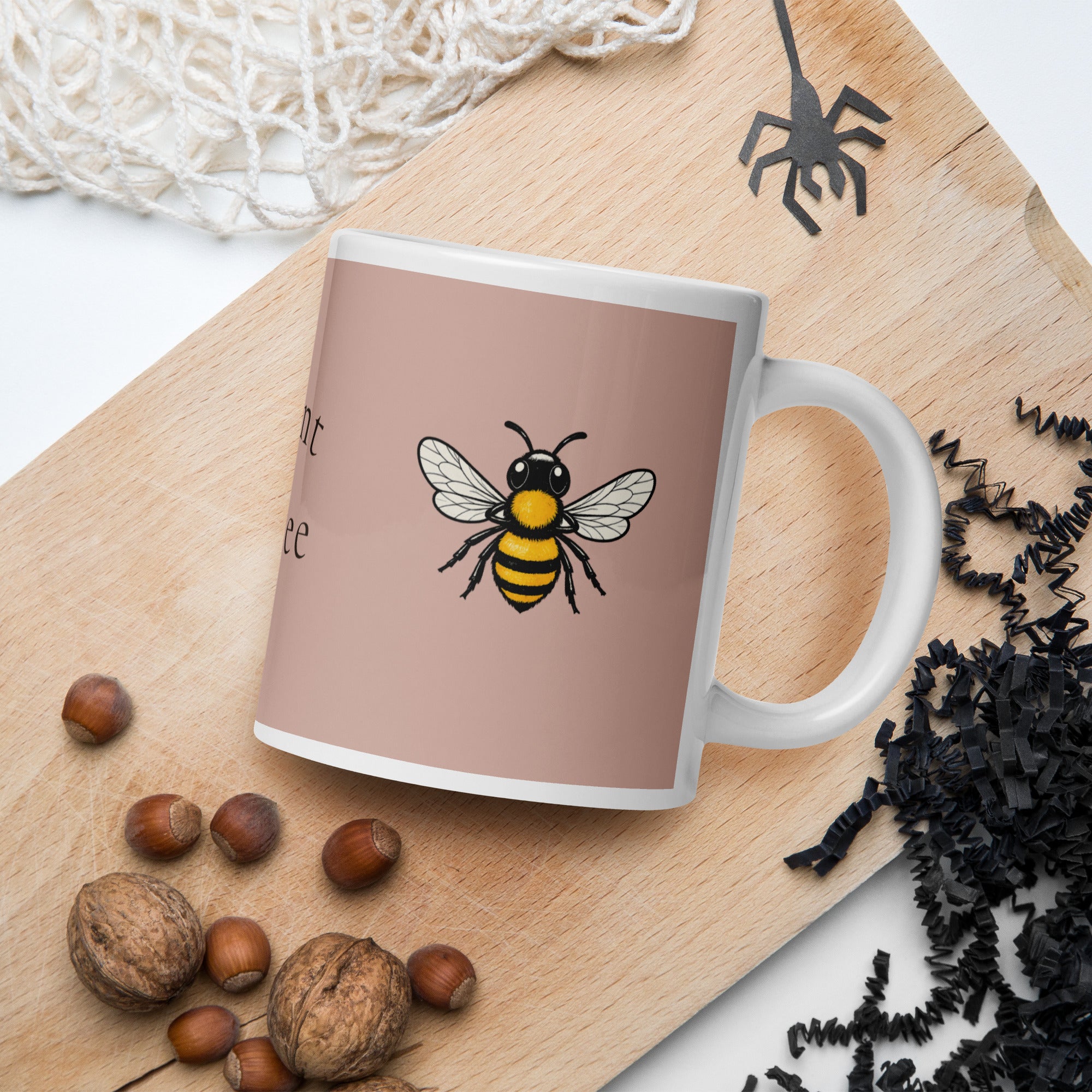 Dusty rose ceramic mug with white rim and handle, front bee illustration