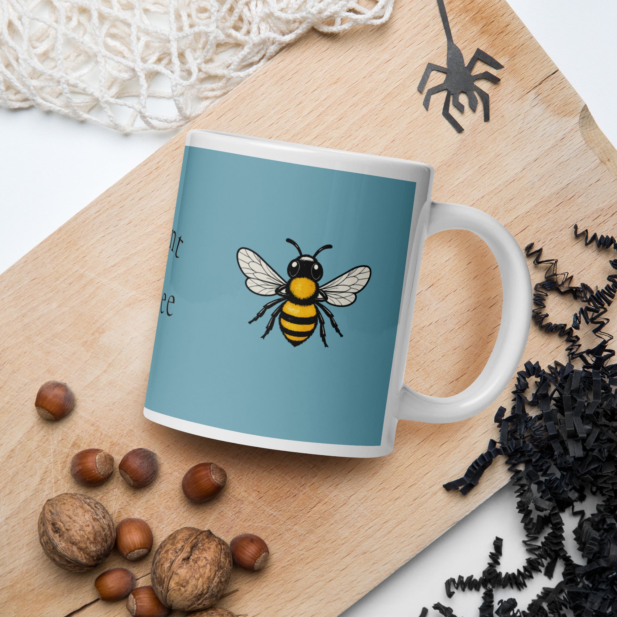 Blue ceramic coffee mug with bee illustration centered on the front
