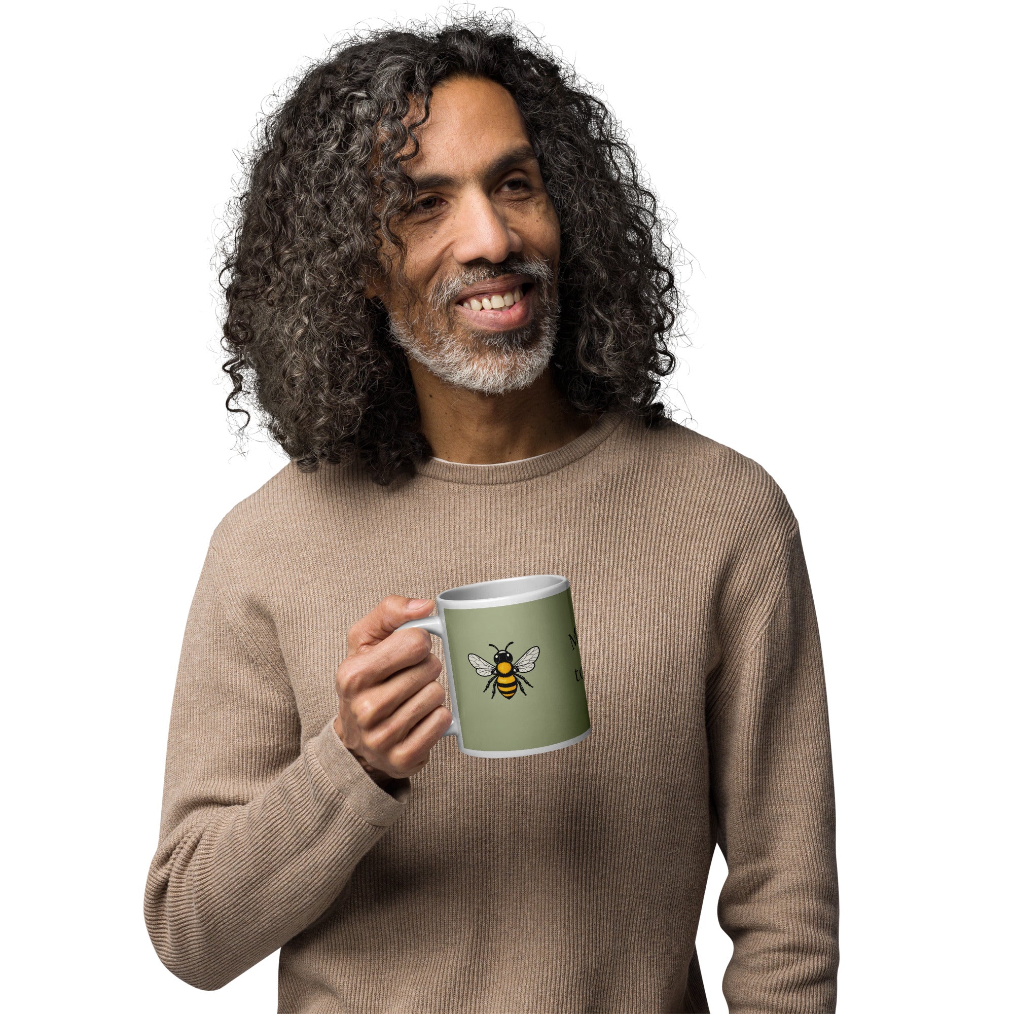Sage green ceramic coffee mug with bee illustration, held at mid-chest