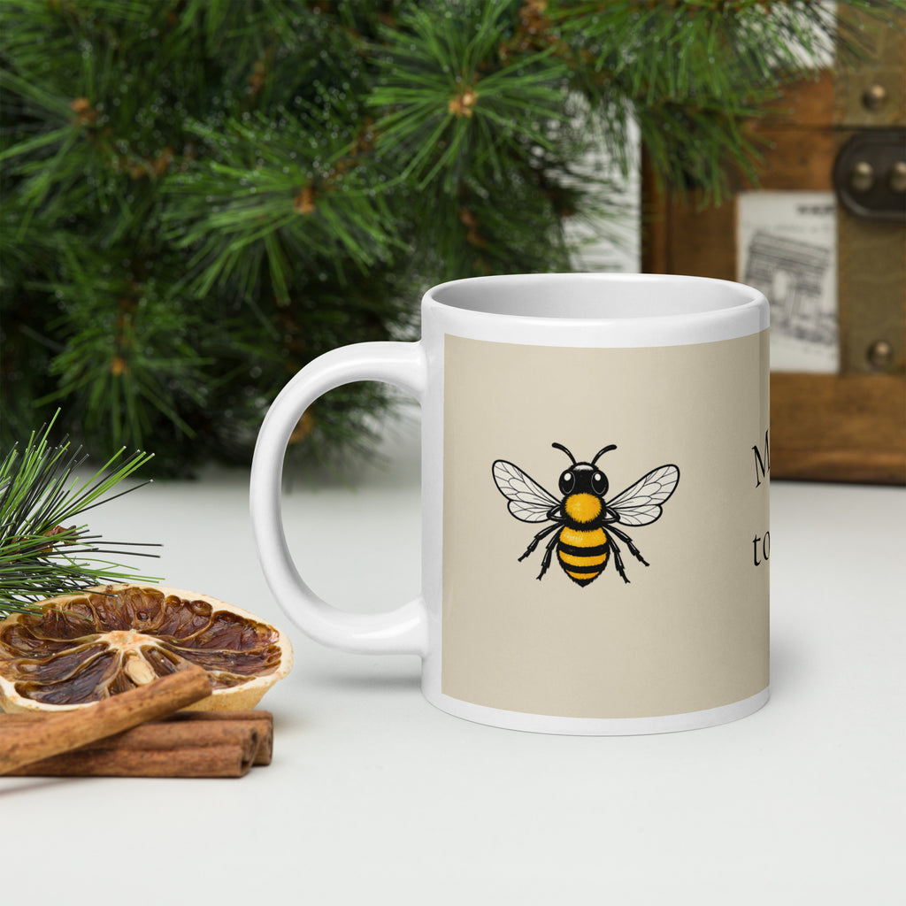 Light beige ceramic mug with bee illustration and partial 'to' text